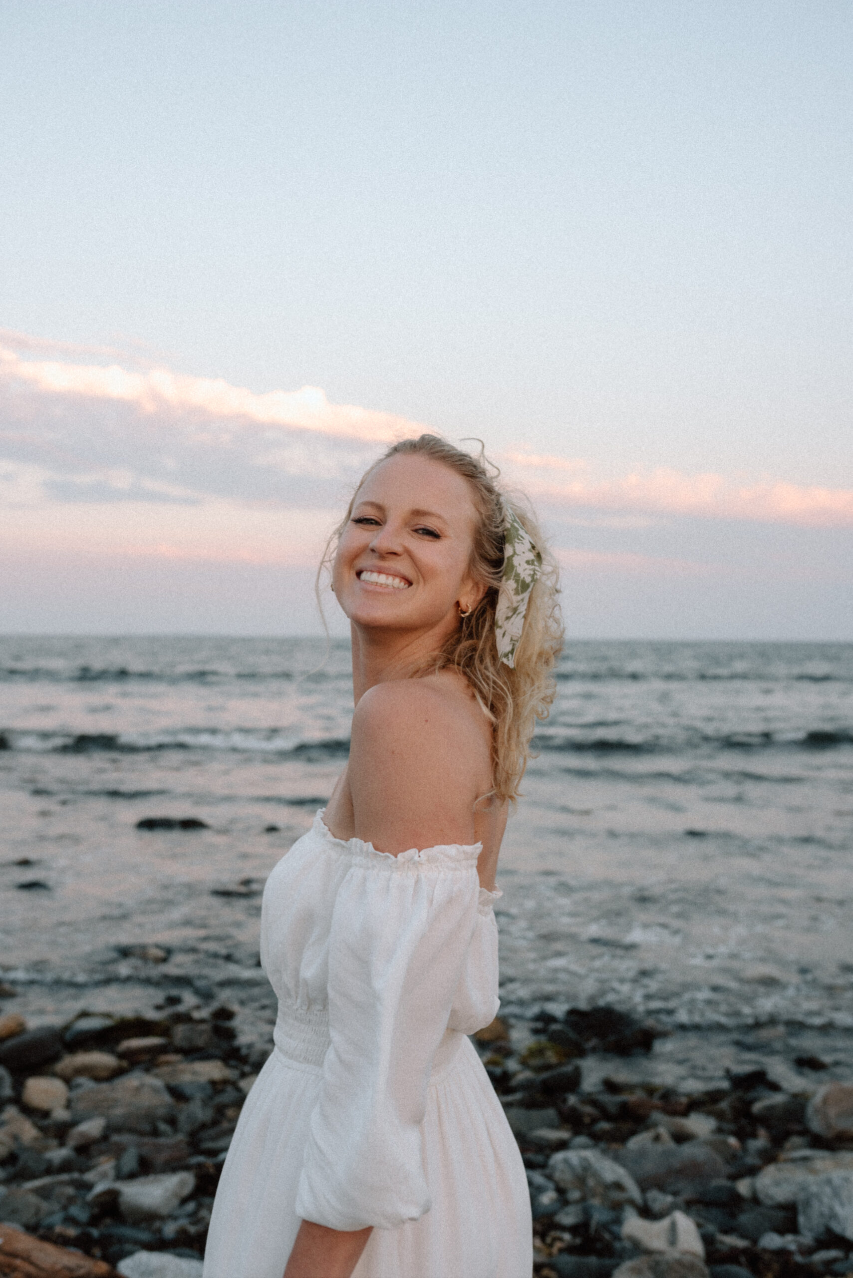 Maine Wedding Photographer poses for a headshot on the beach