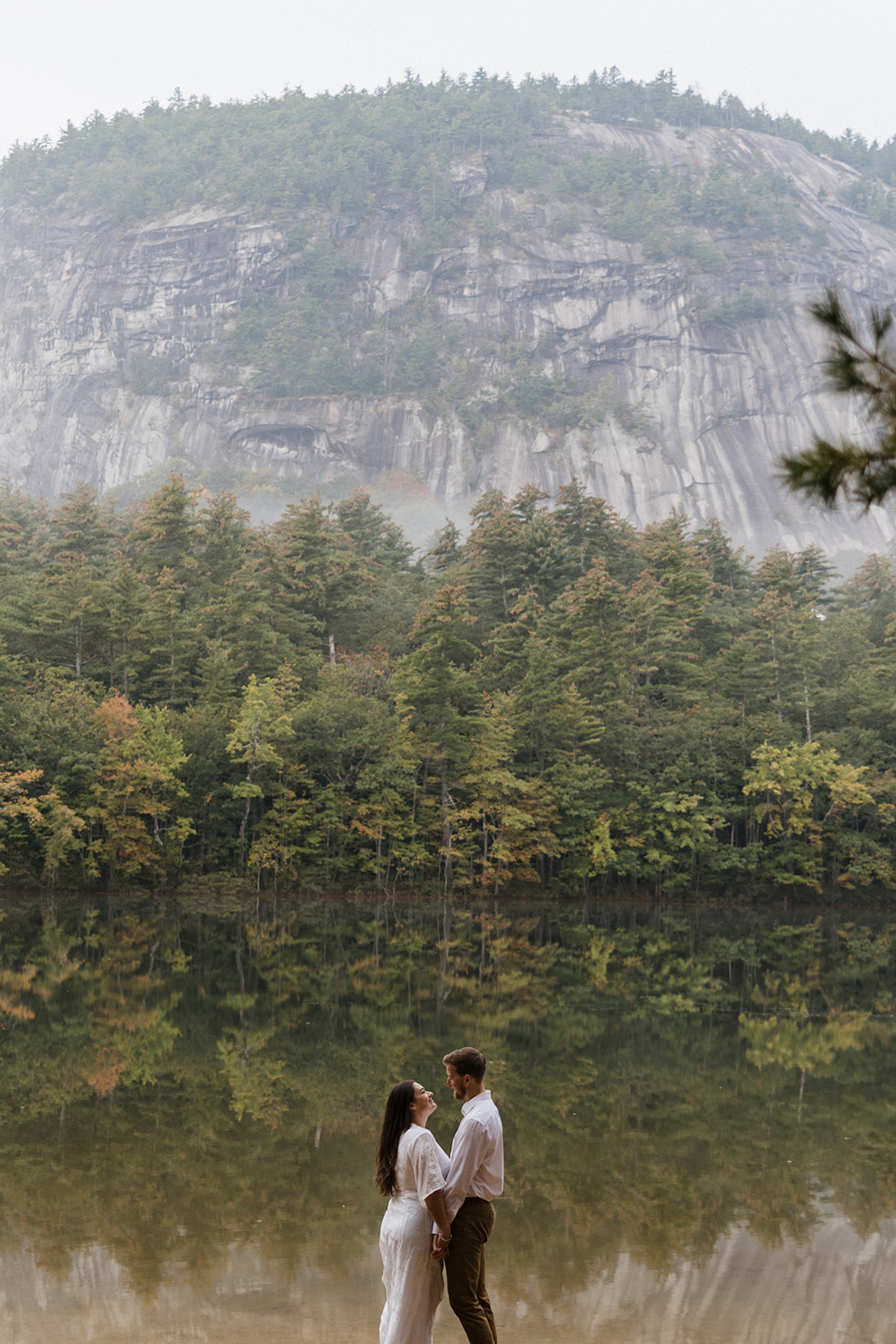 bride and groom pose together with cathedral ledge in the background