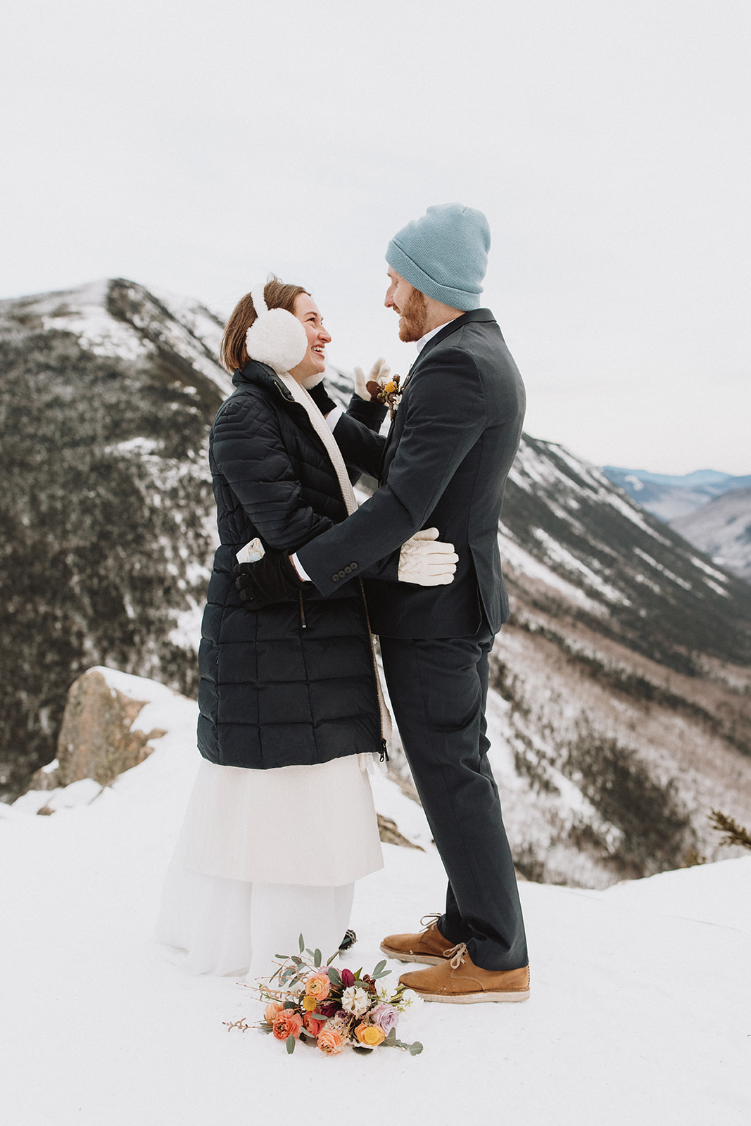 bride and groom pose together during their snowy winter NH elopement