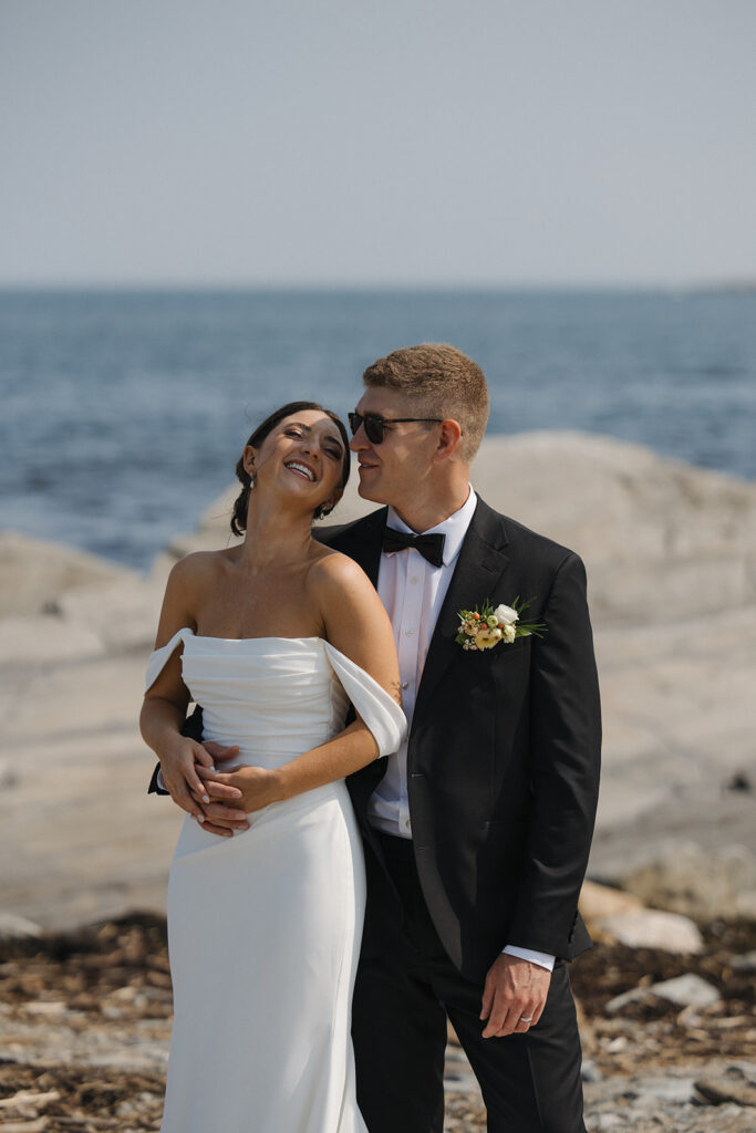 Couple laughing while taking their wedding day portraits on the Seacoast of New Hampshire