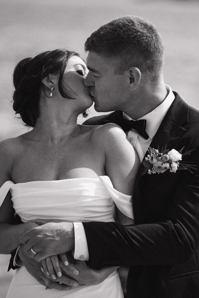 Bride and groom romantically kissing while taking photos on the seacoast of new hampshire 