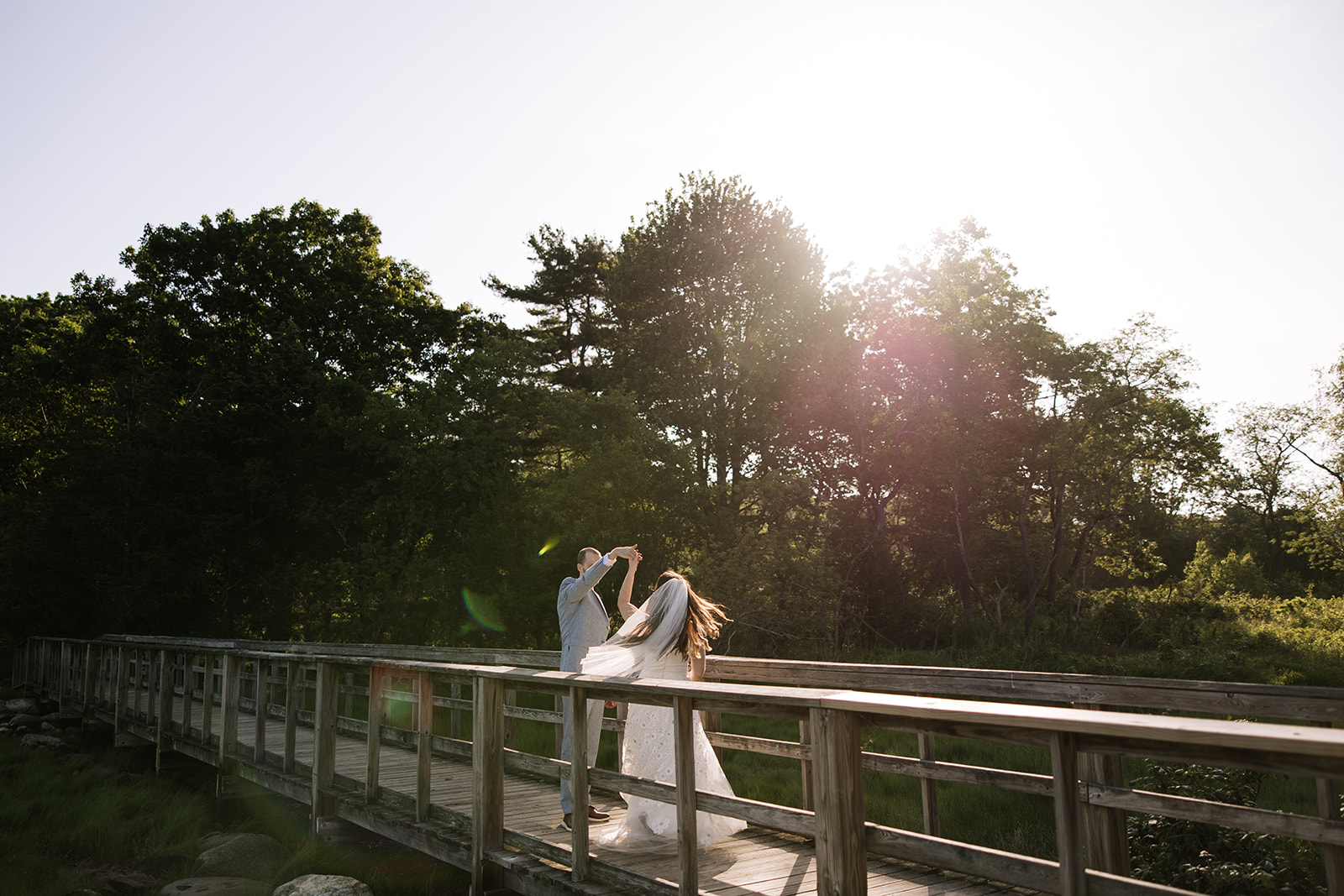 Couple dancing in the sunlight on a bridge in rye new hampshire