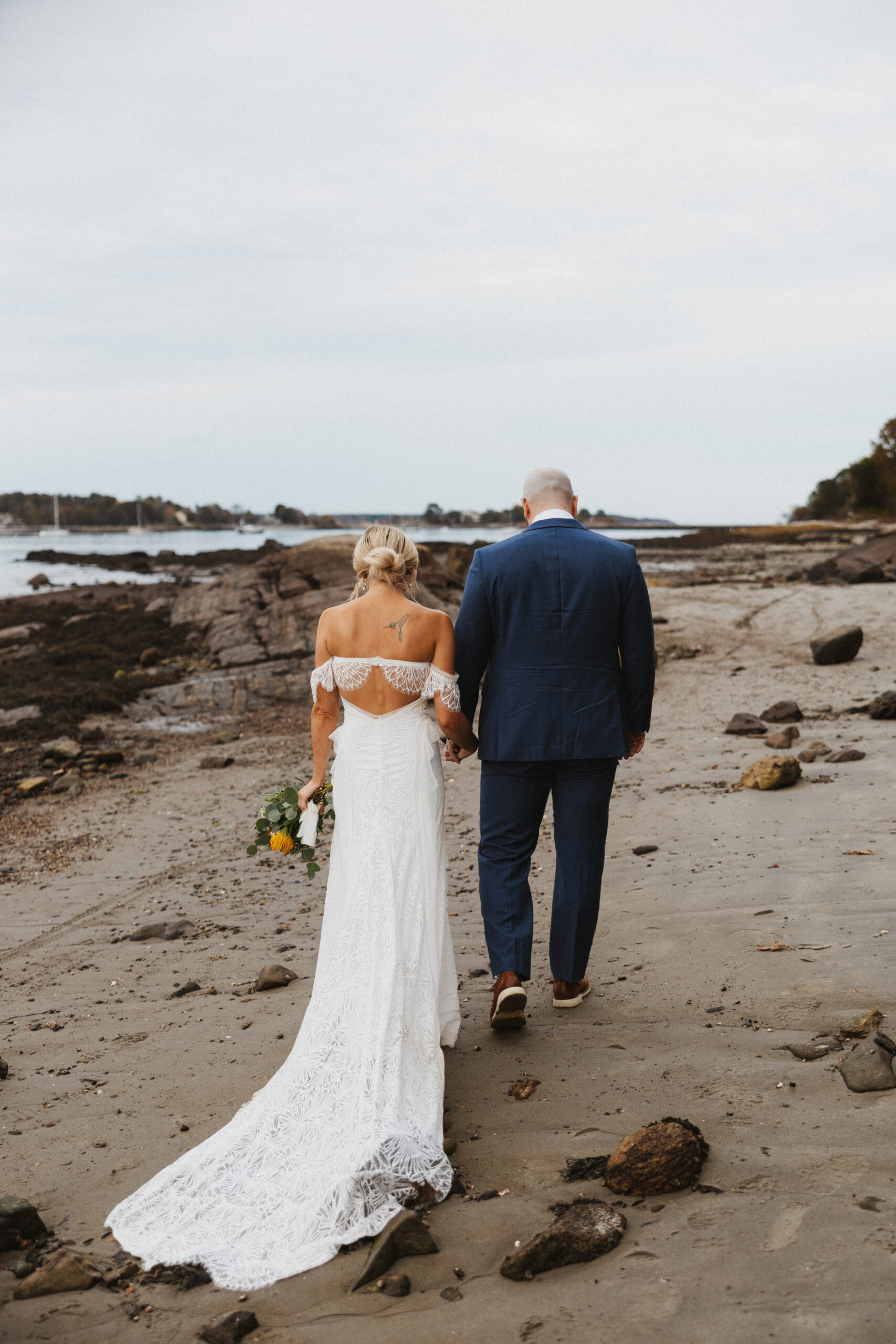 Bride and Groom walking down the beach on their Seacoast New Hampshire Wedding Day