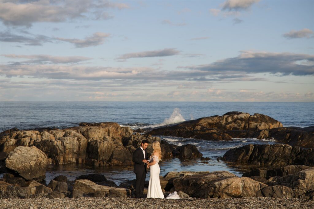 Couple exchanging vows on the gorgeous seacoast of New Hampshire with waves crashing in the background. 