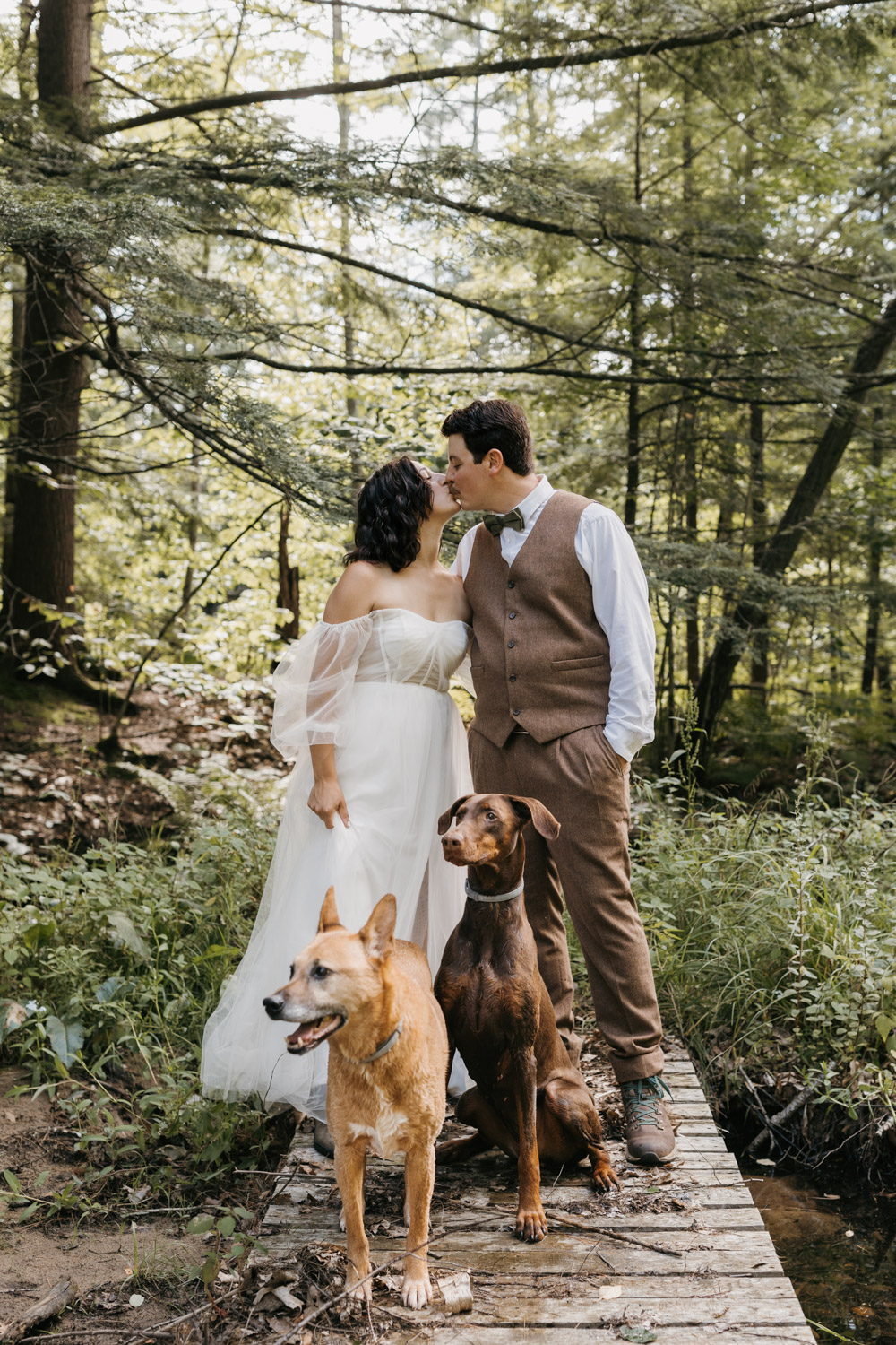 Bride and groom with their pups at the fish hatchery in New Hampton, New Hampshire