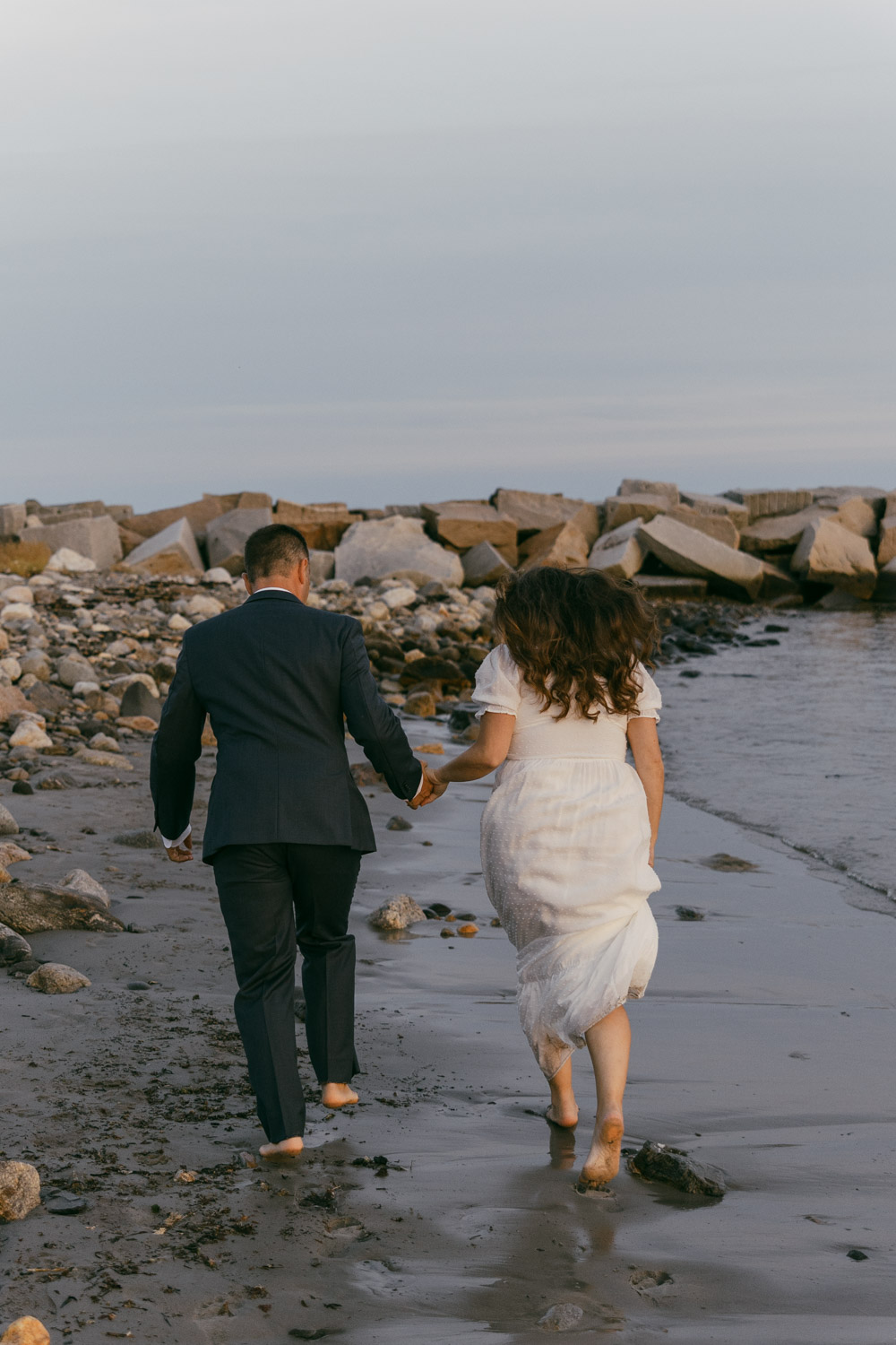 couple holding hands during their rye harbor state park elopement.