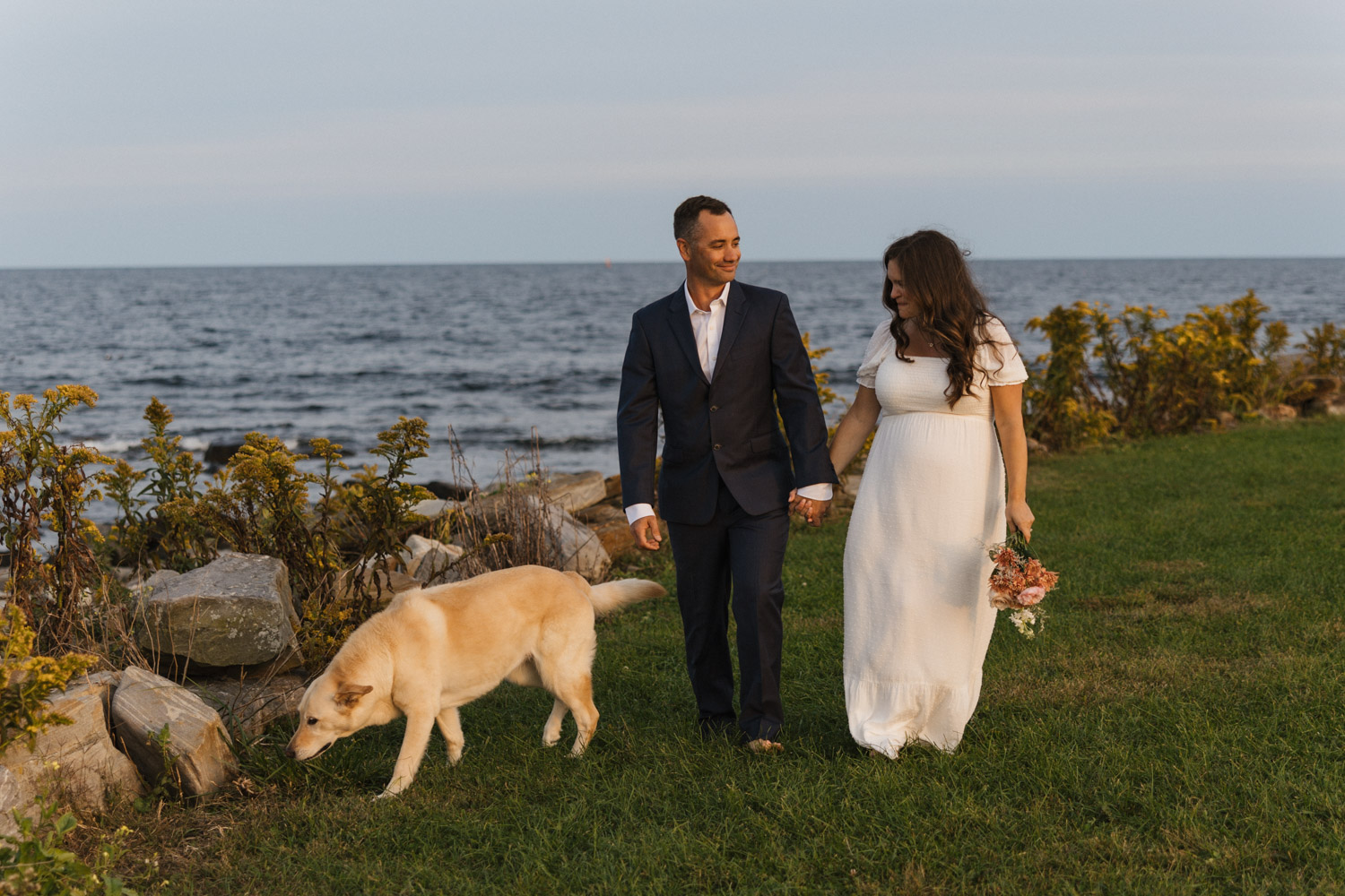 couple posing during their rye harbor state park elopement with their dog.