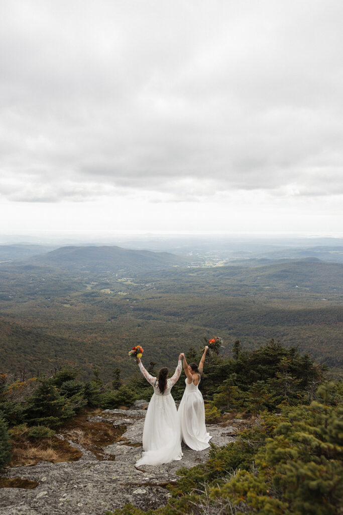 Two brides celebrating at the top of Mount Mansfield in Stowe, Vermont
