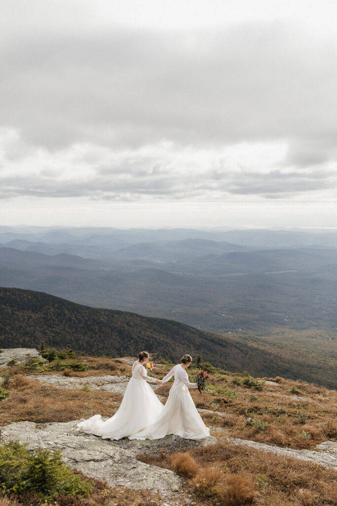 Two brides walking on top of Mount Mansfield at their Elopement in Stowe, Vermont