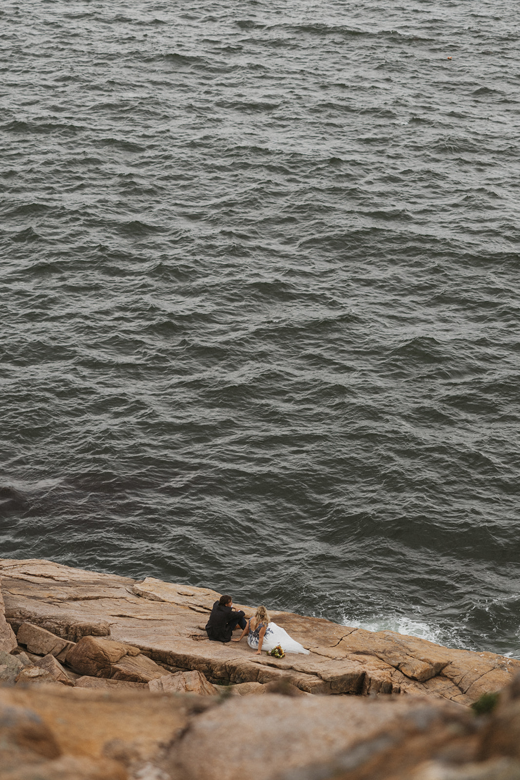 Bride and groom enjoy a moment on the cliffs in Acadia National Park