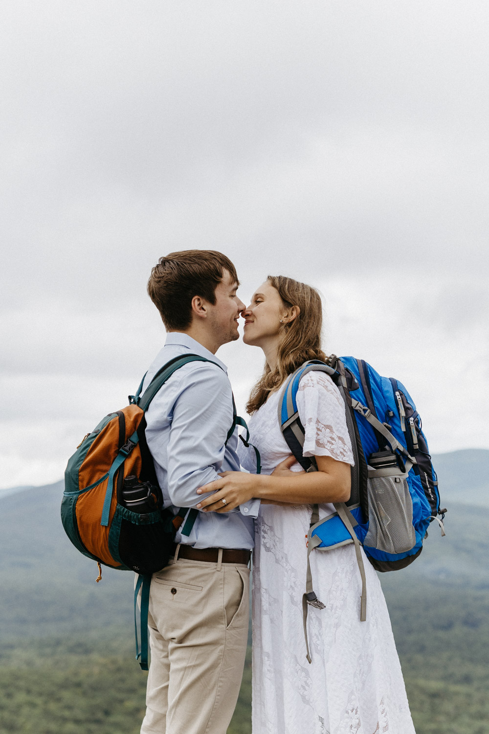 couple share a kiss during their White mountain hiking engagement photos