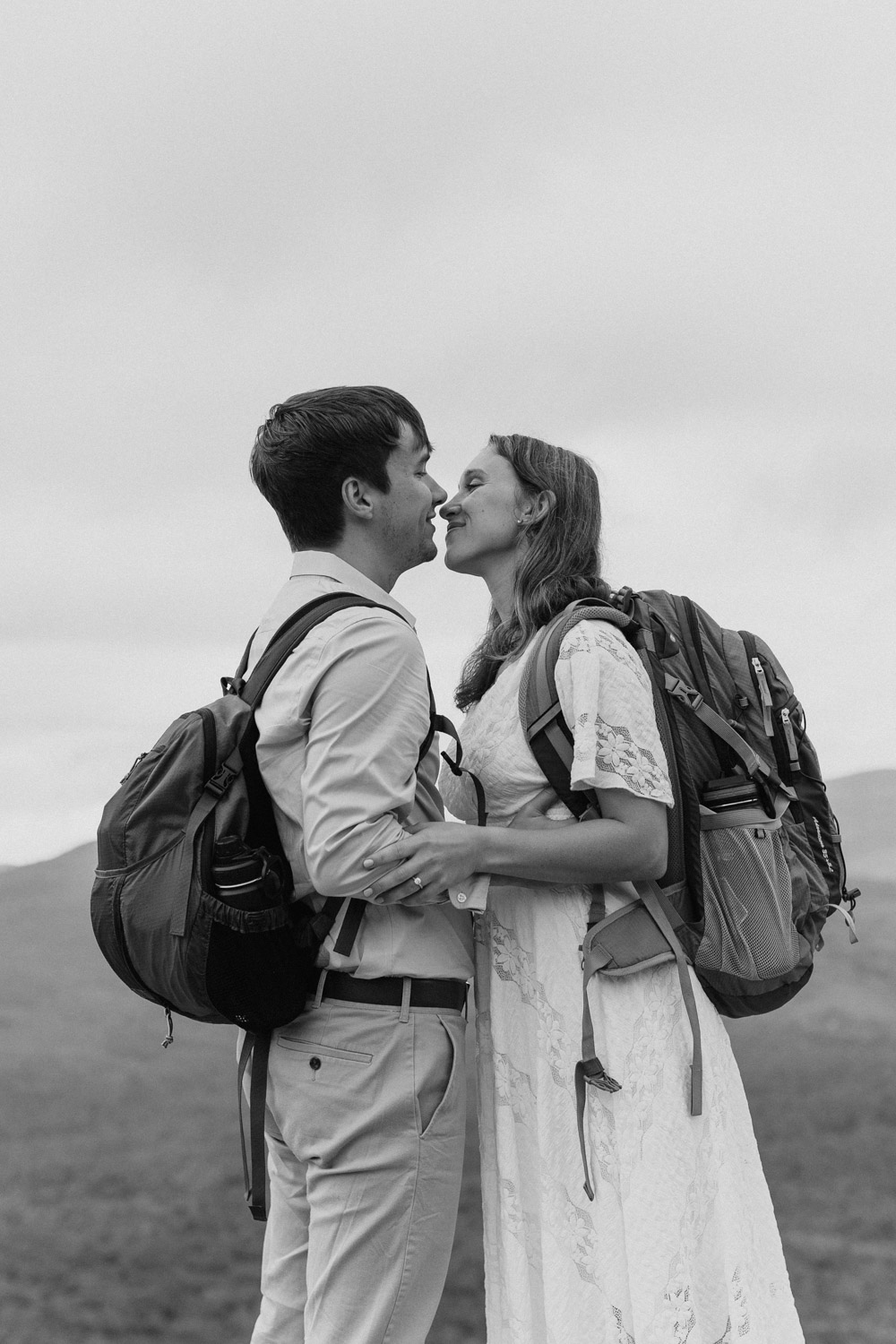 couple share a kiss with the stunning White mountains in the background