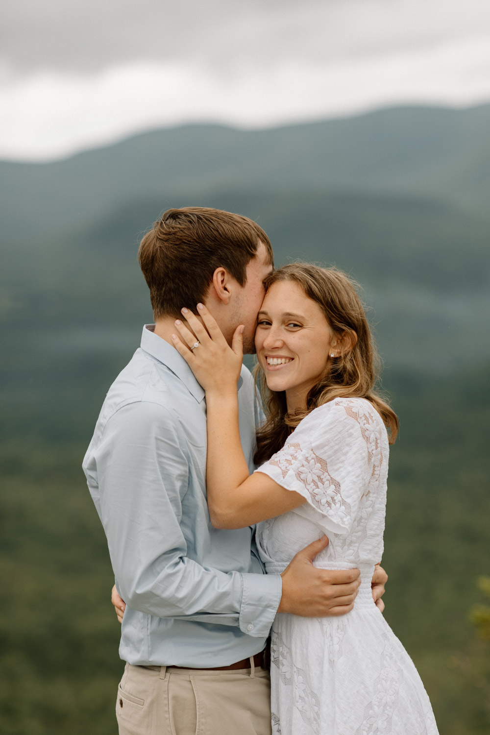 couple share a kiss with the stunning White mountains in the background