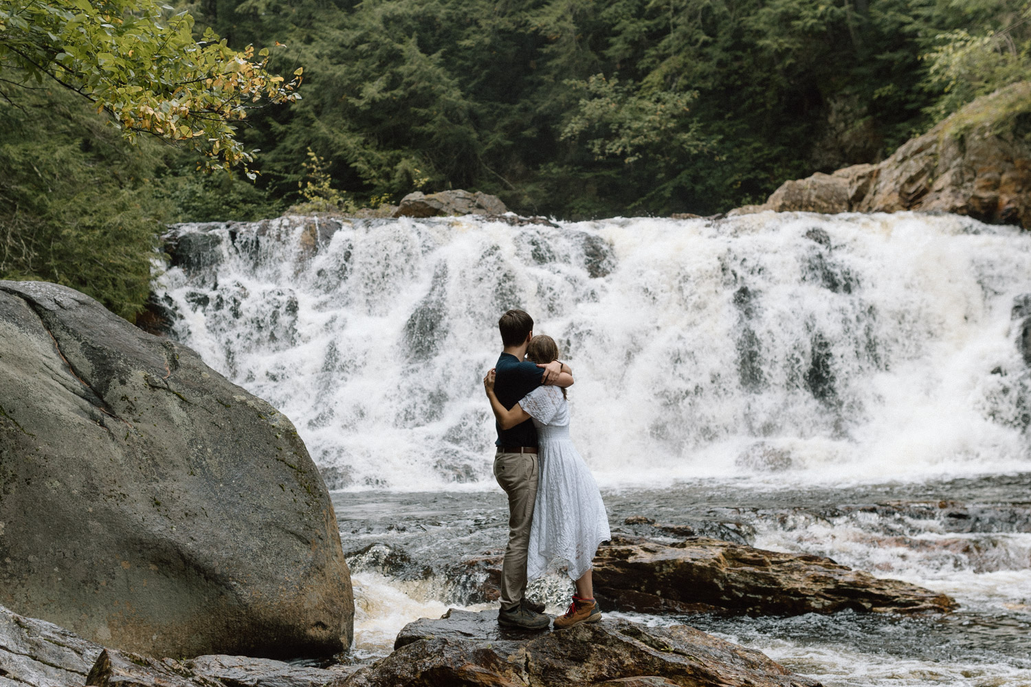 couple pose together with the stunning waterfall in the background