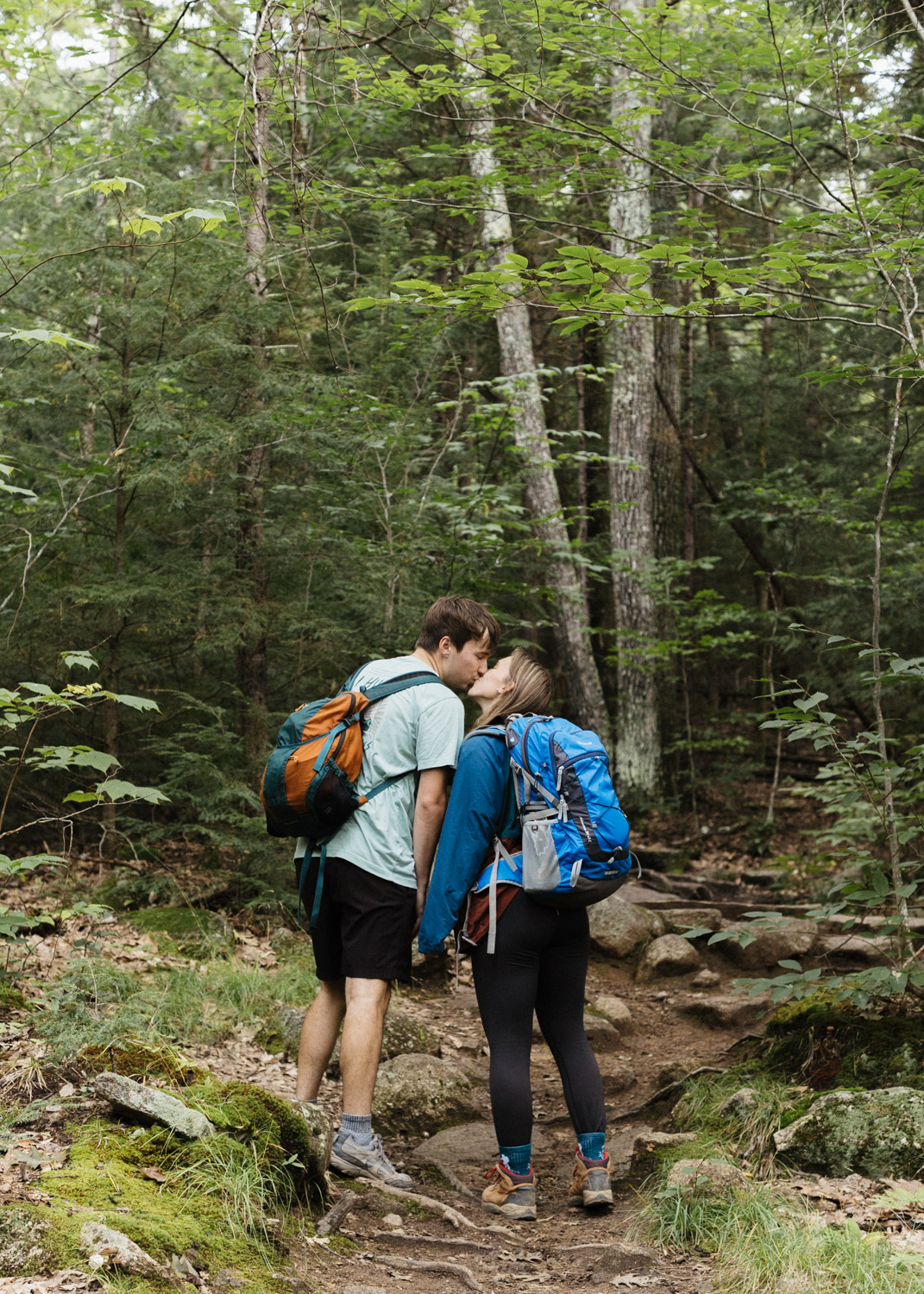 beautiful couple share a kiss during their hiking engagement in the stunning White mountains 