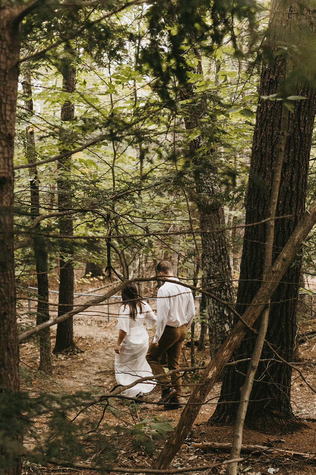 couple walk through the woods 