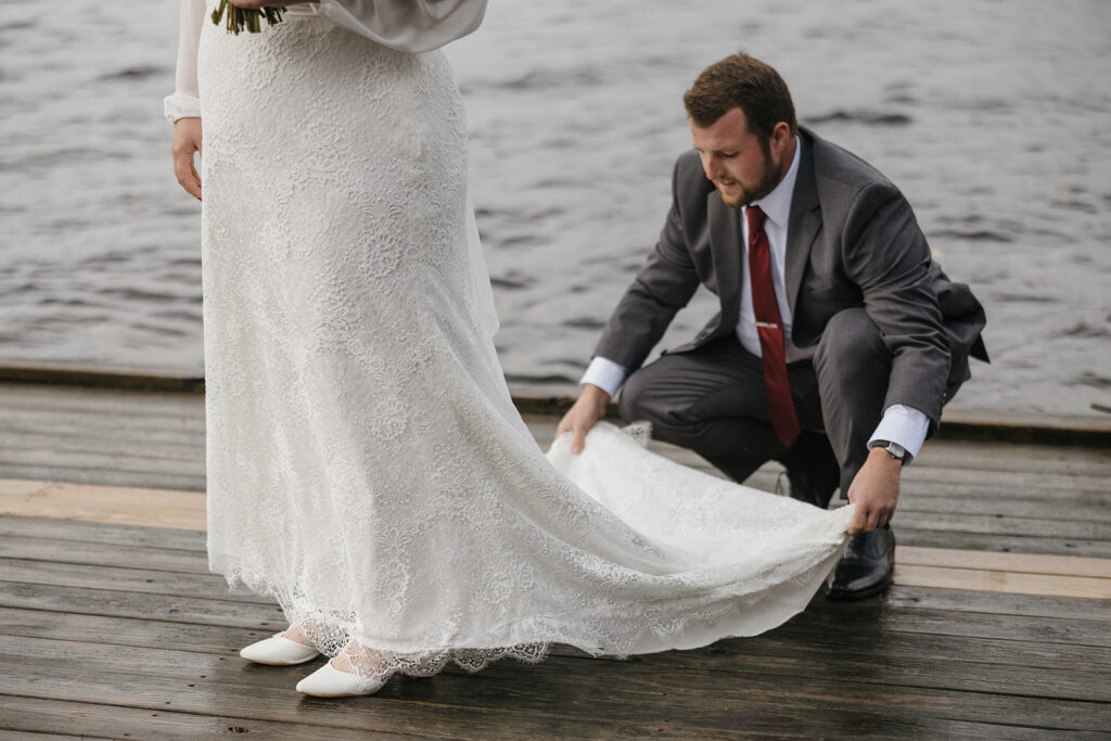 groom fixes his brides dress before their ceremony