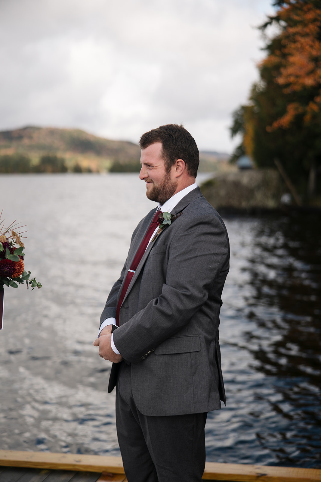 bride and groom surrounded by friends and family on a lake dock say I do