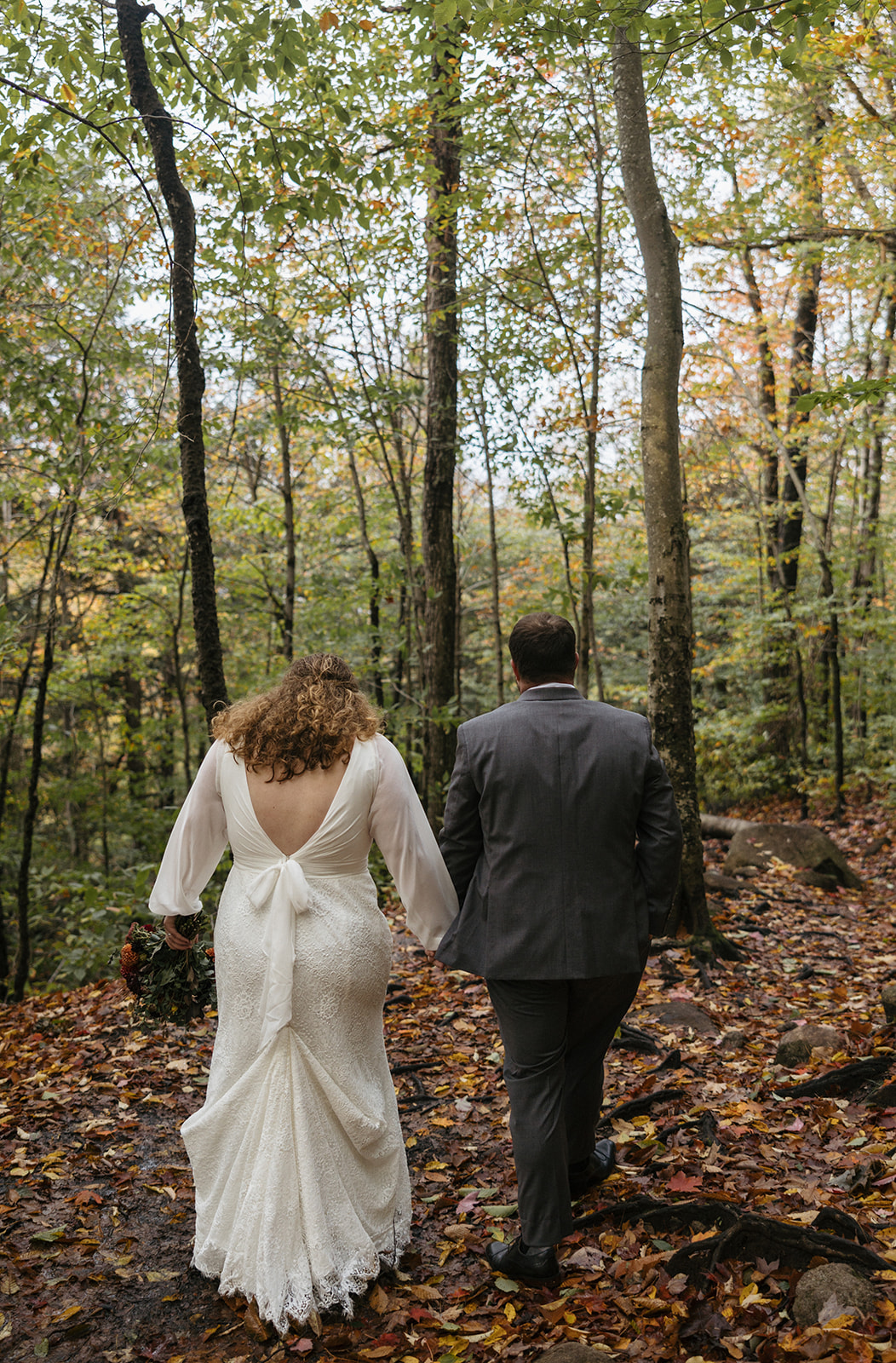 bride and groom hike through the Autumn foliage in upstate New York