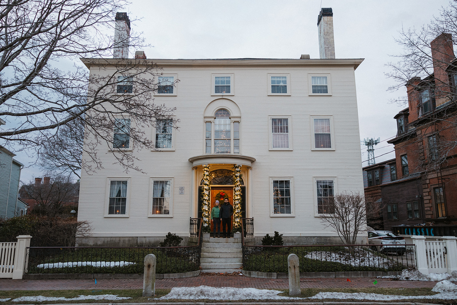 stunning couple pose outside their stunning New Hampshire home