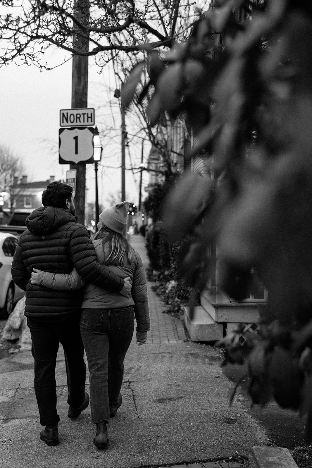 couple walk the streets together during their documentary style engagement photoshoot