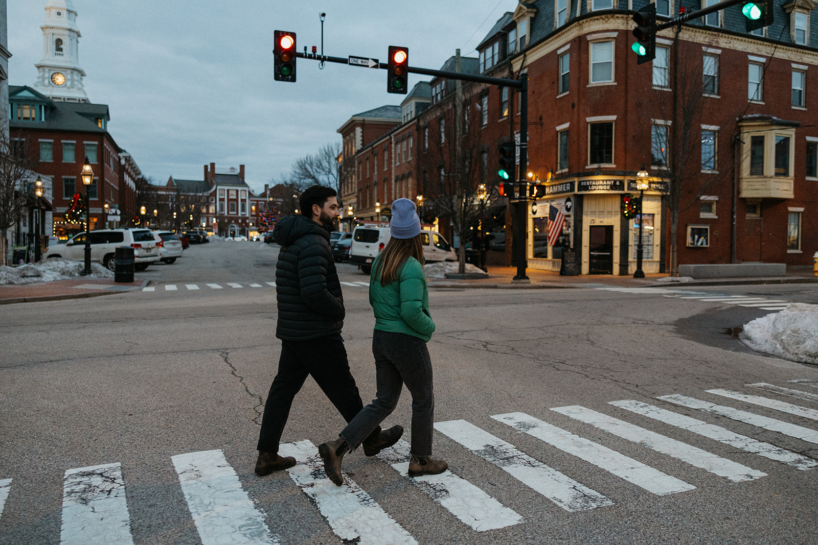 couple walk the streets together during their documentary style engagement photoshoot