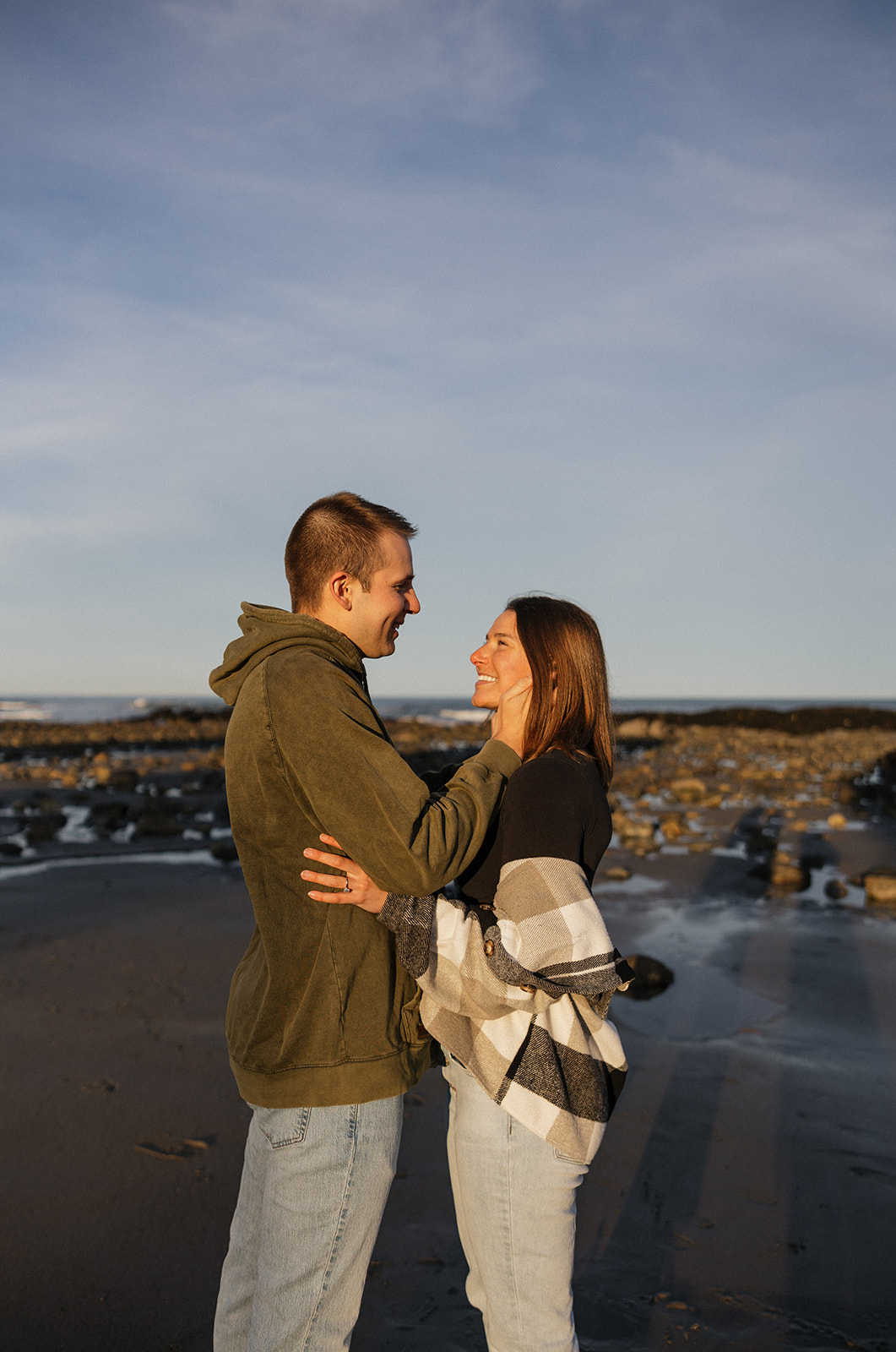 beautiful couple pose on an East Coast beach during their engagement photoshoot