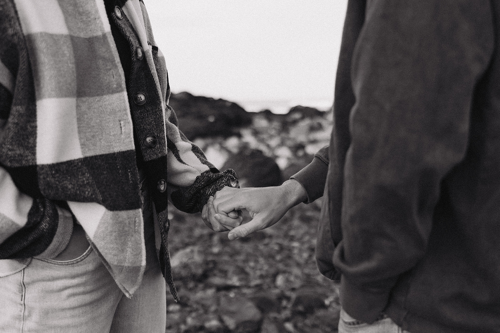 stunning couple pose on a New Hampshire beach during their East coast engagement photos