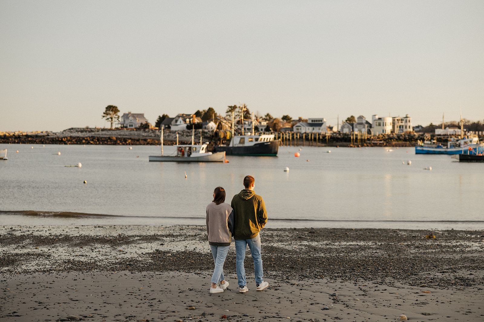 beautiful couple pose on an East Coast beach during their engagement photoshoot