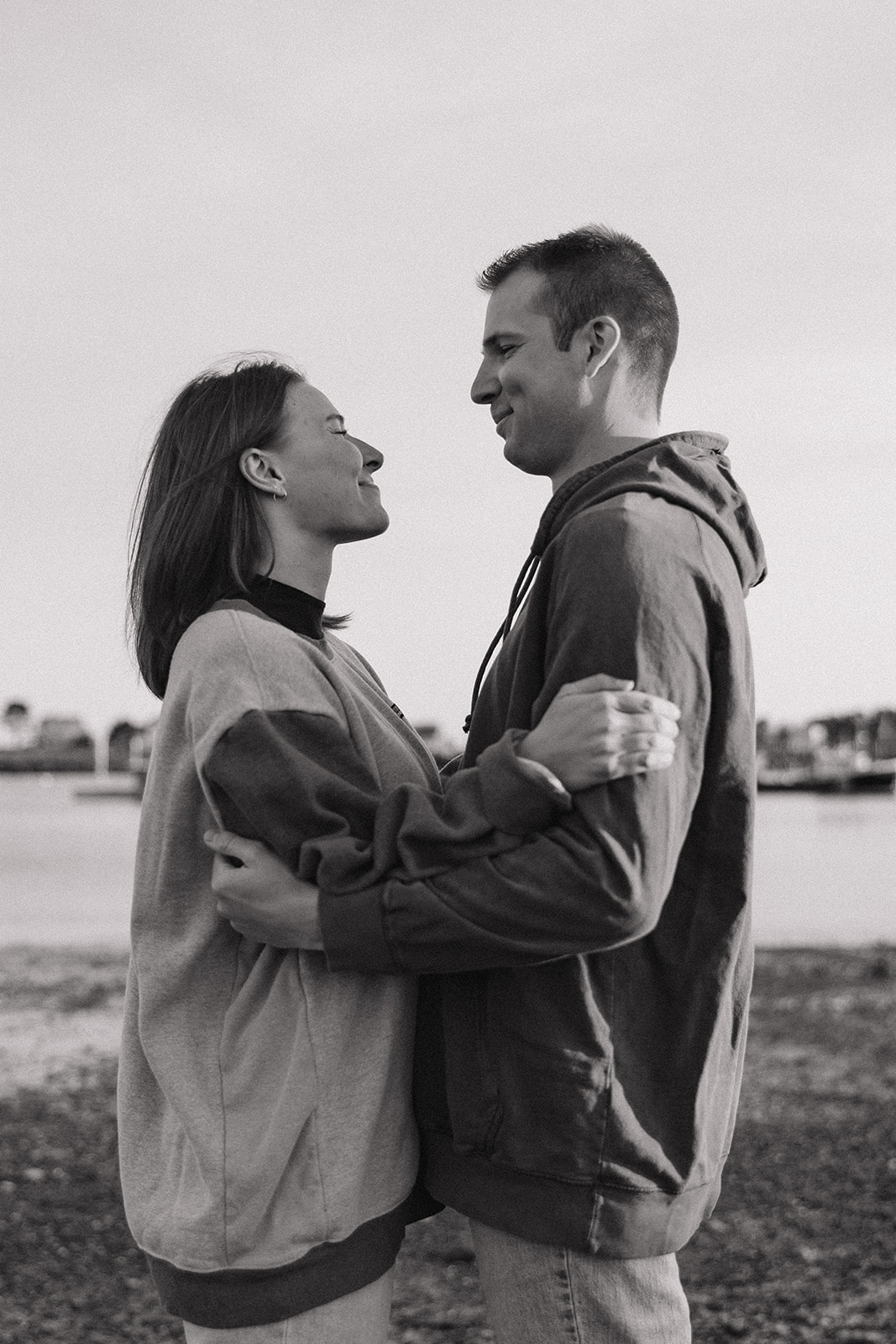 stunning couple pose on a New Hampshire beach during their East coast engagement photos