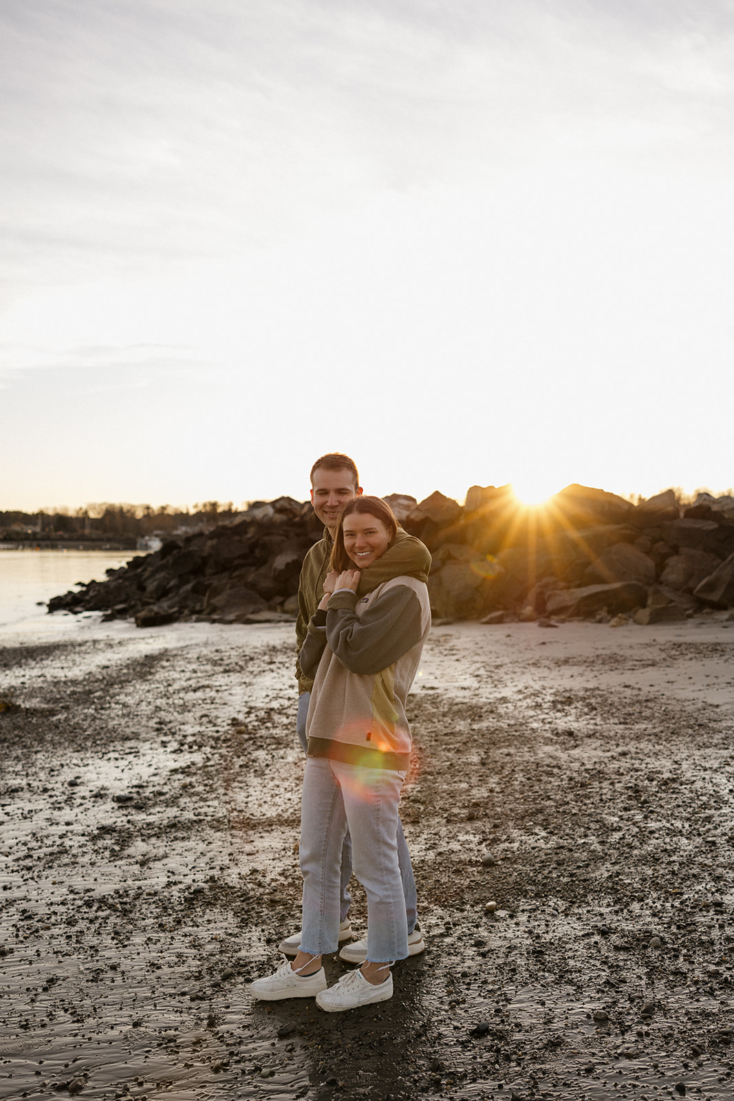 stunning couple pose on a New Hampshire beach during their East coast engagement photos