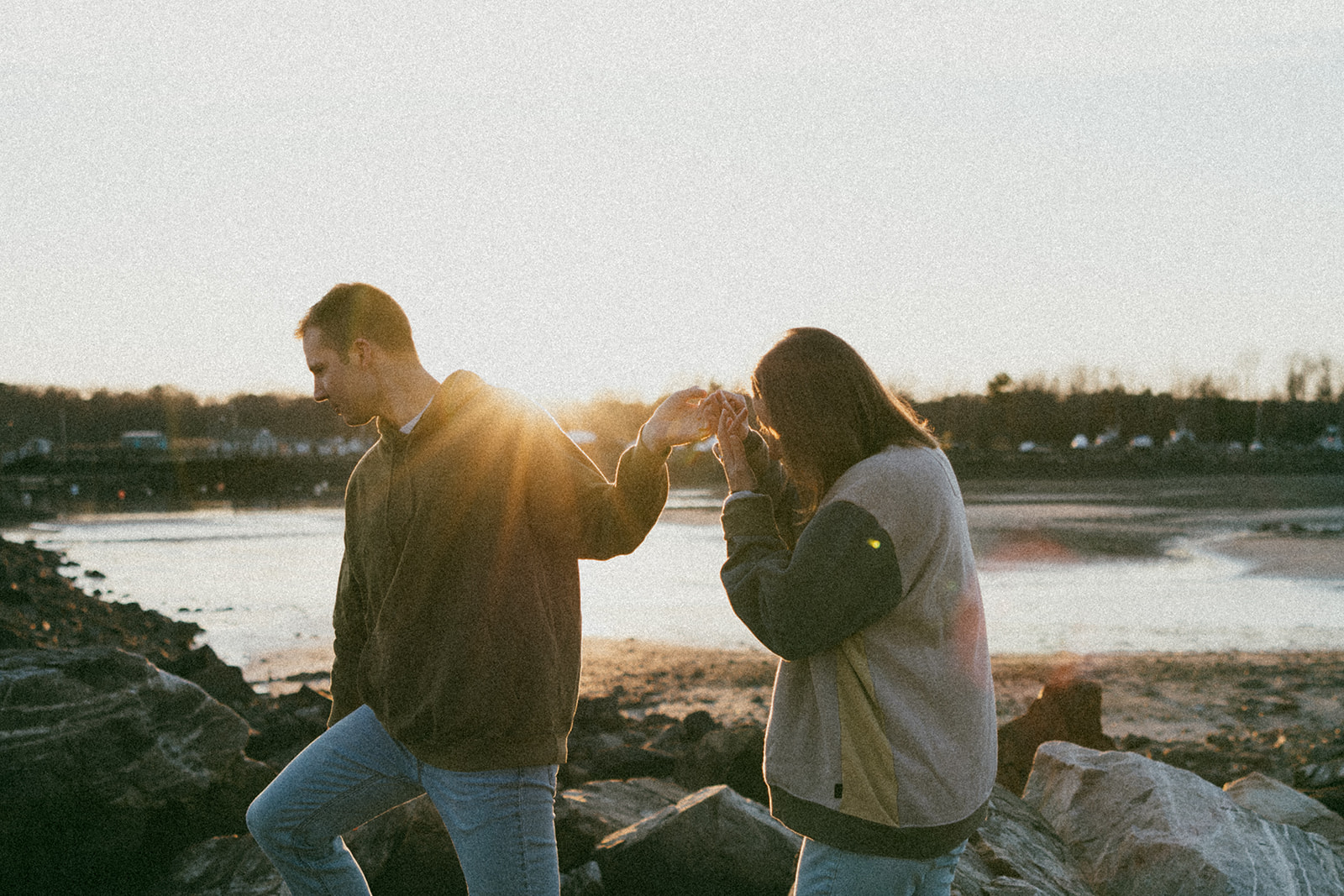 stunning couple pose on a New Hampshire beach during their East coast engagement photos