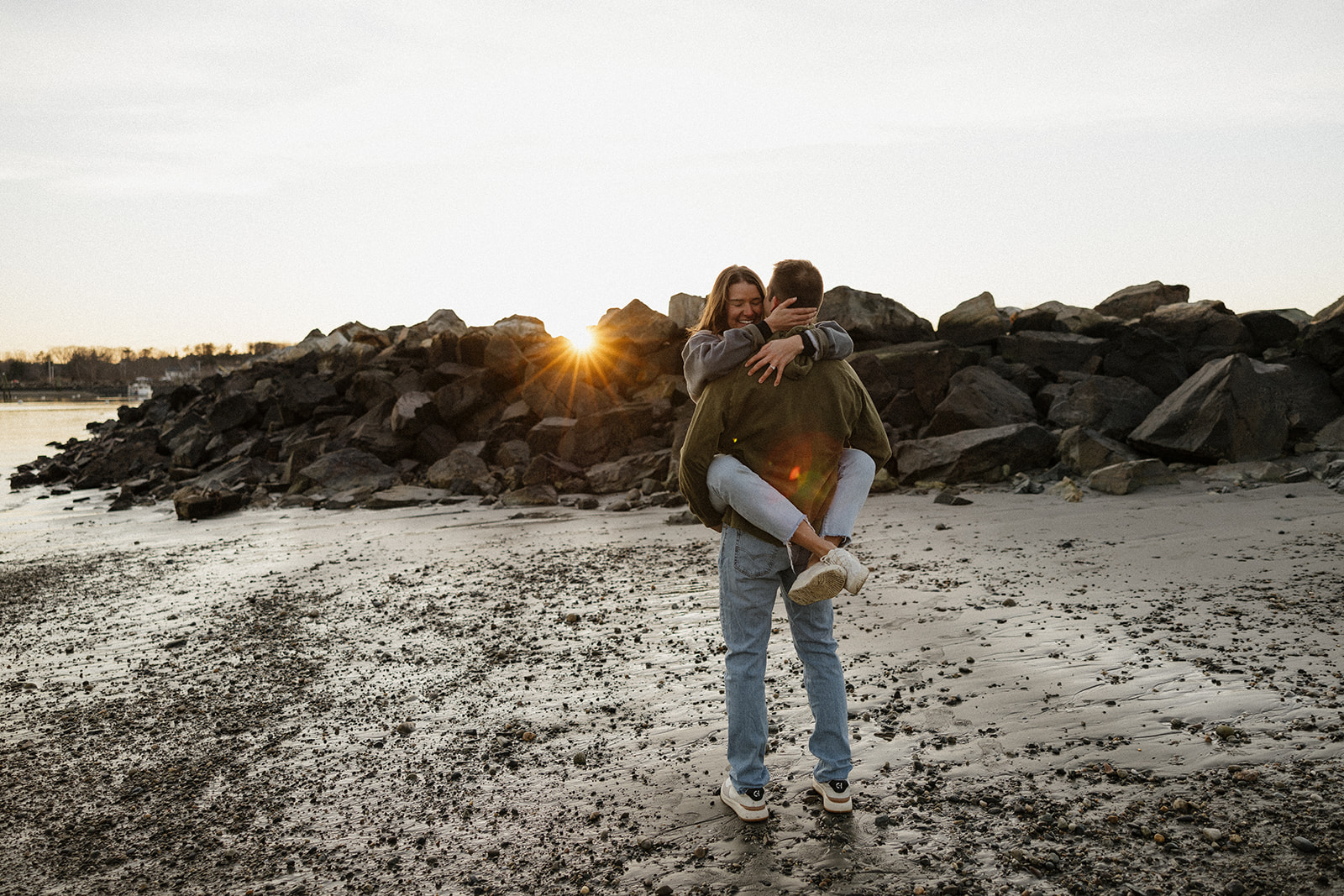 beautiful couple pose on an East Coast beach during their engagement photoshoot