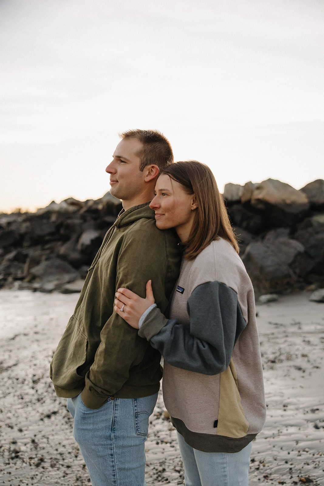 stunning couple pose on a New Hampshire beach during their East coast engagement photos