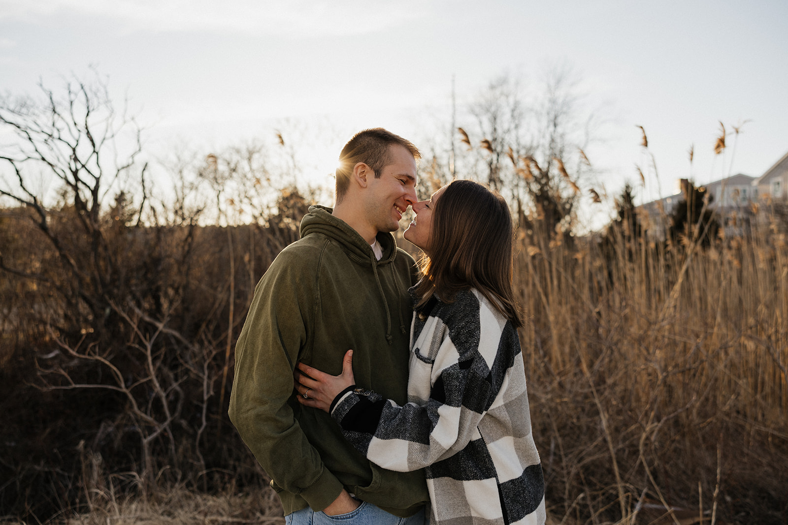 stunning couple pose on a New Hampshire beach during their East coast engagement photos