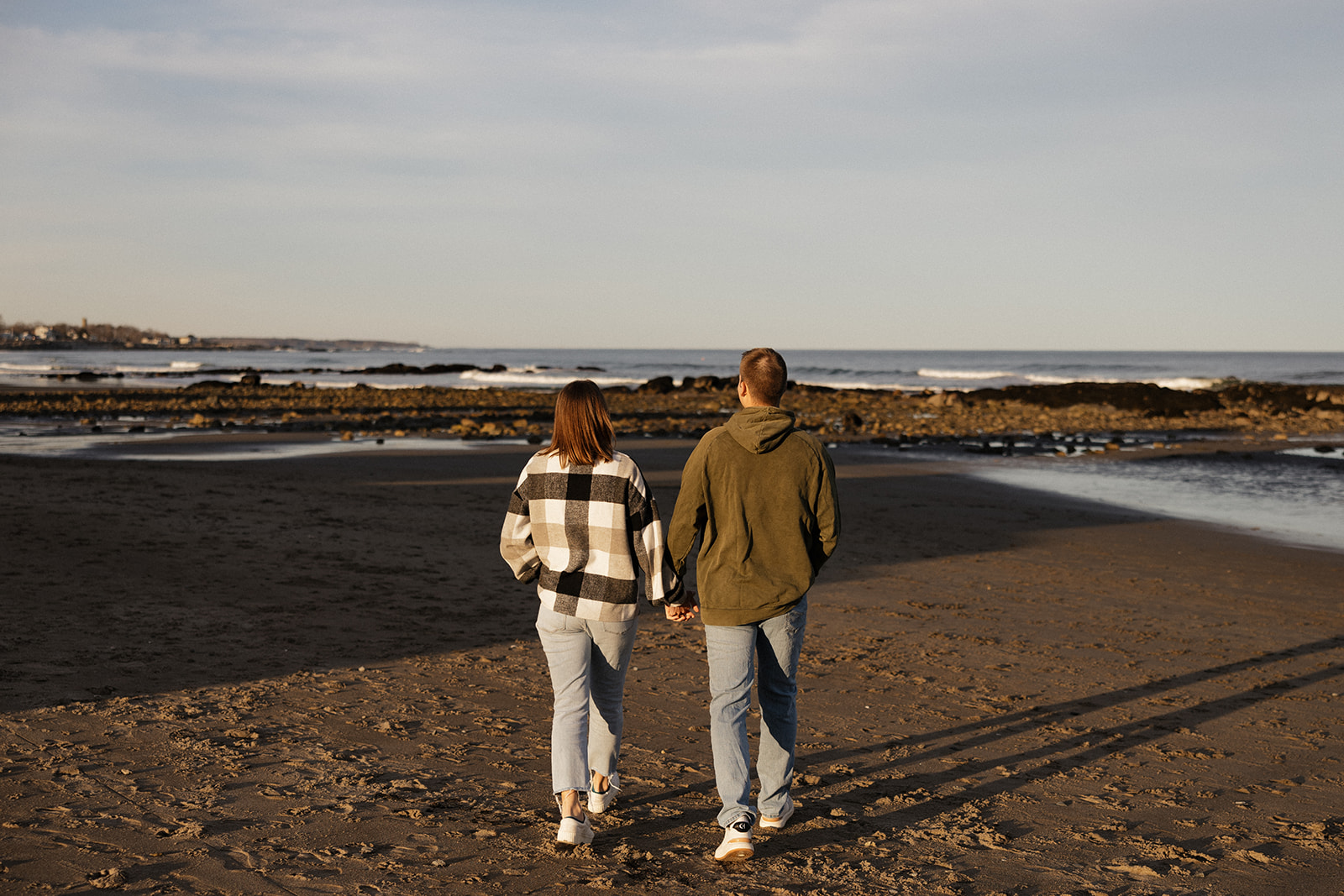 beautiful couple pose on an East Coast beach during their engagement photoshoot