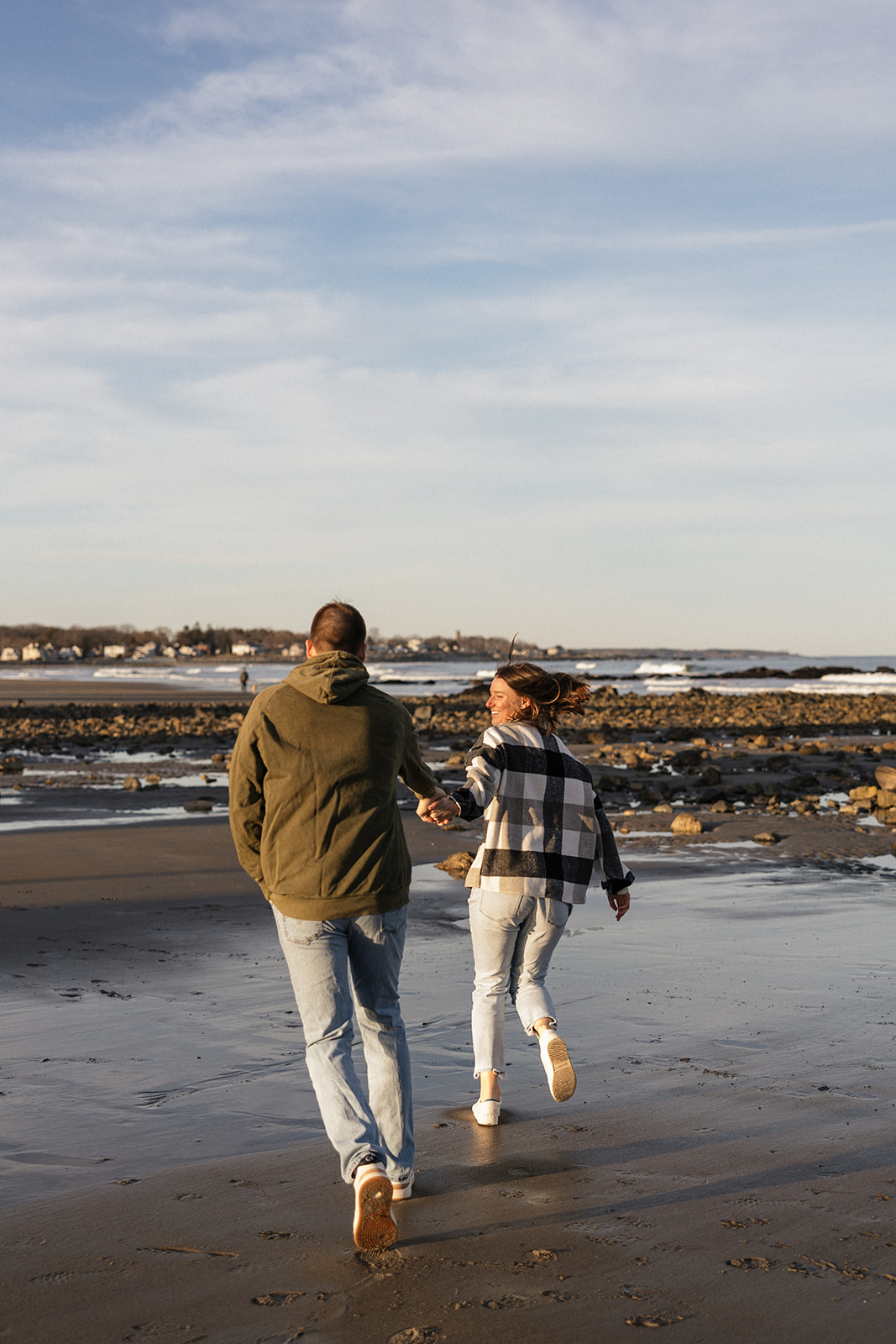 stunning couple pose on a New Hampshire beach during their East coast engagement photos