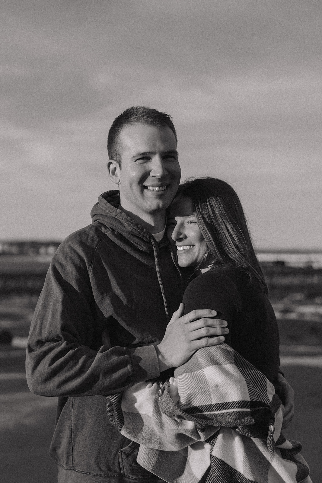 beautiful couple pose on an East Coast beach during their engagement photoshoot