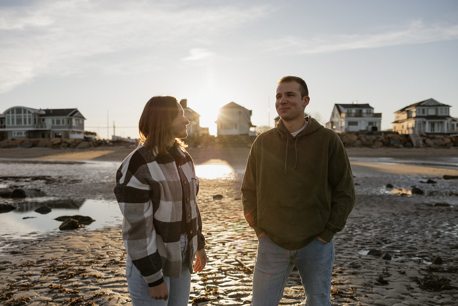 beautiful couple pose on an East Coast beach during their engagement photoshoot