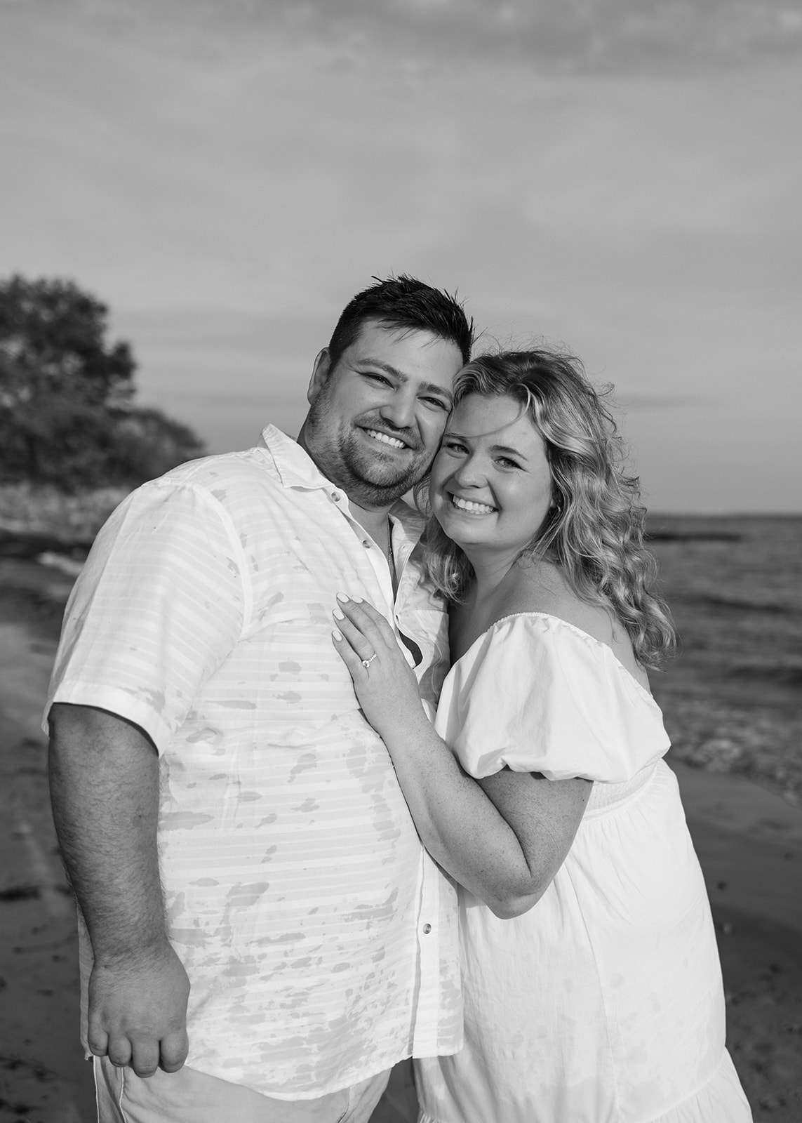 beautiful couple pose with their dog on an East Coast beach