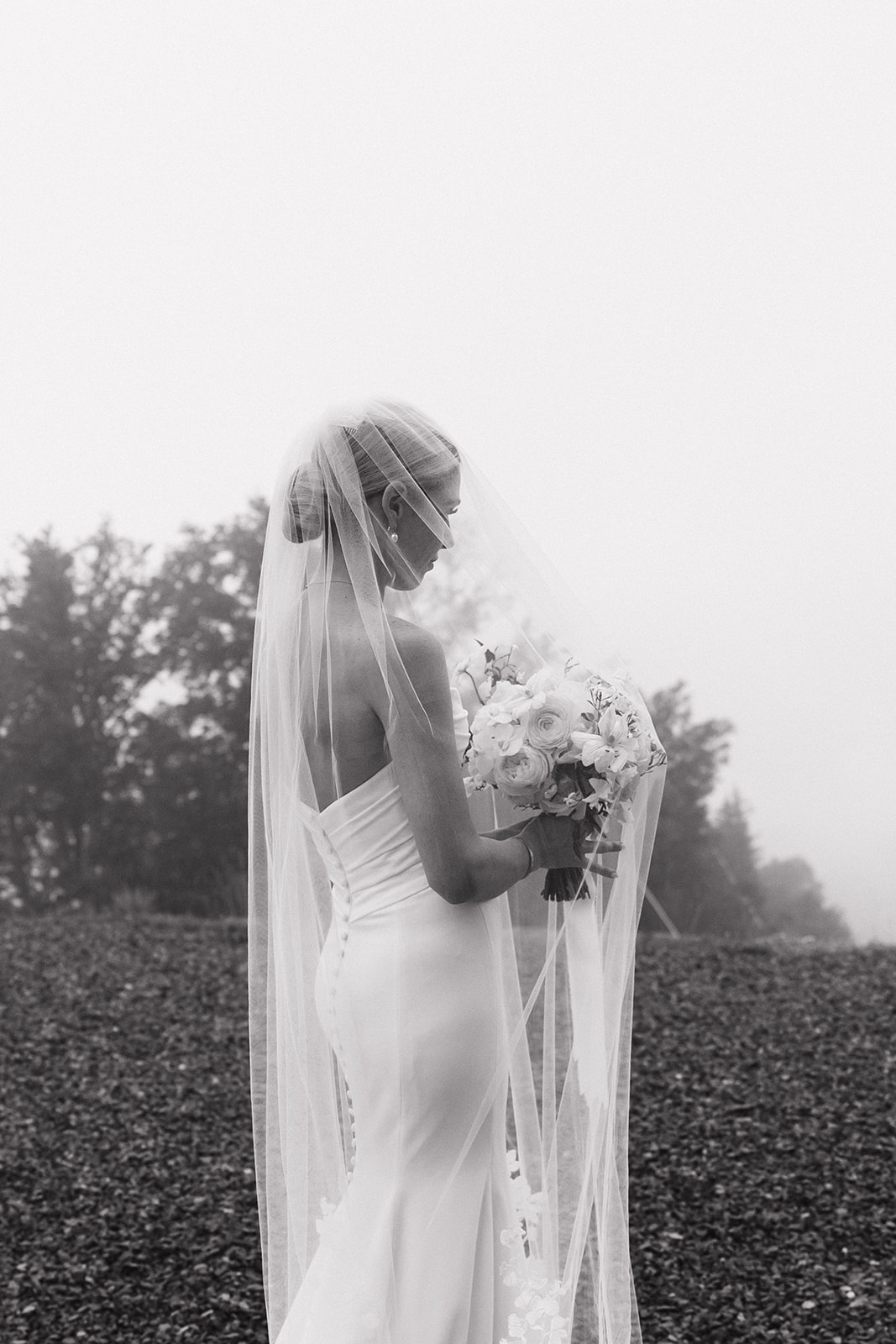 bride poses against a green shrub