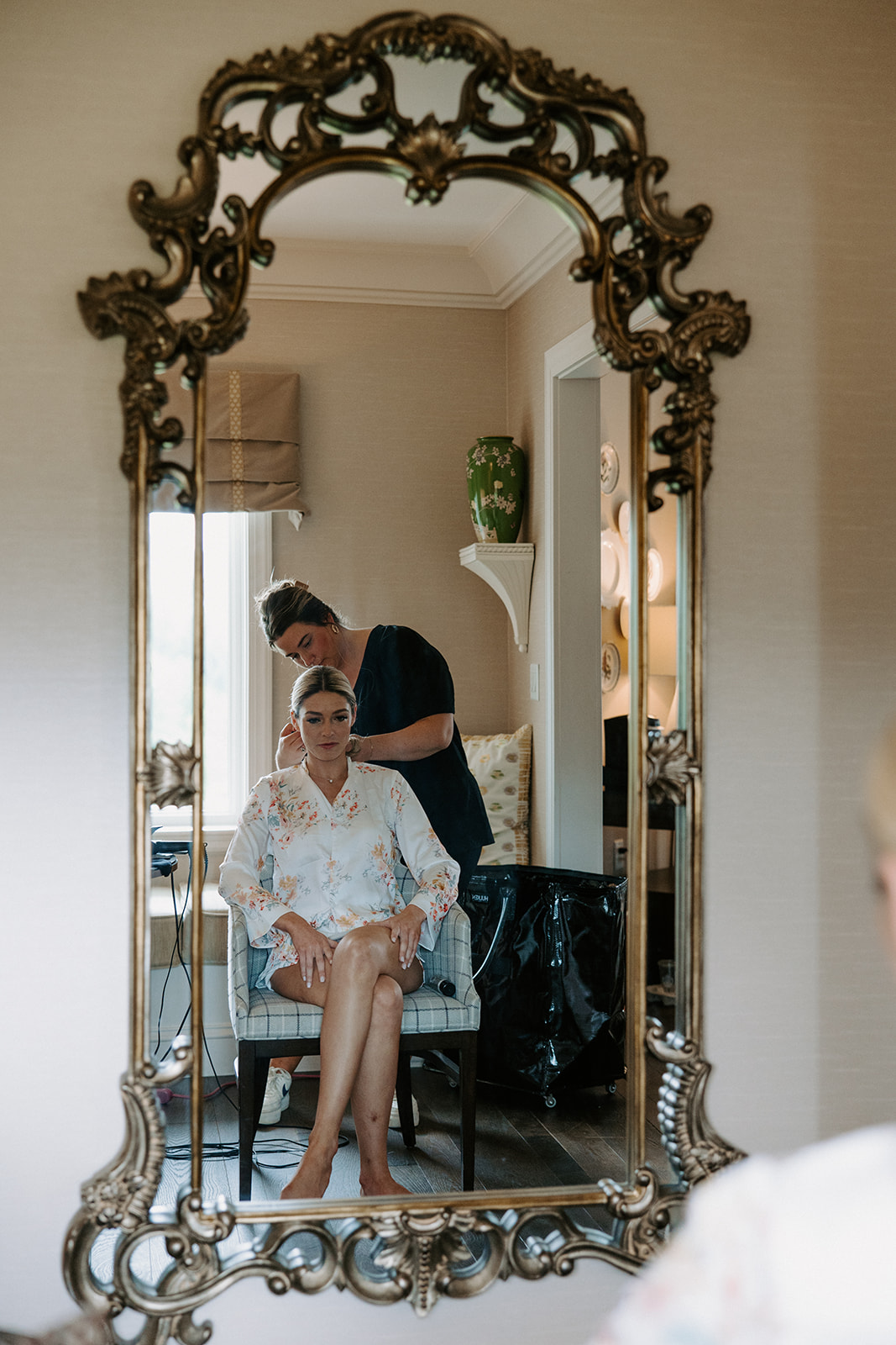 bride gets help preparing for her stunning wedding day