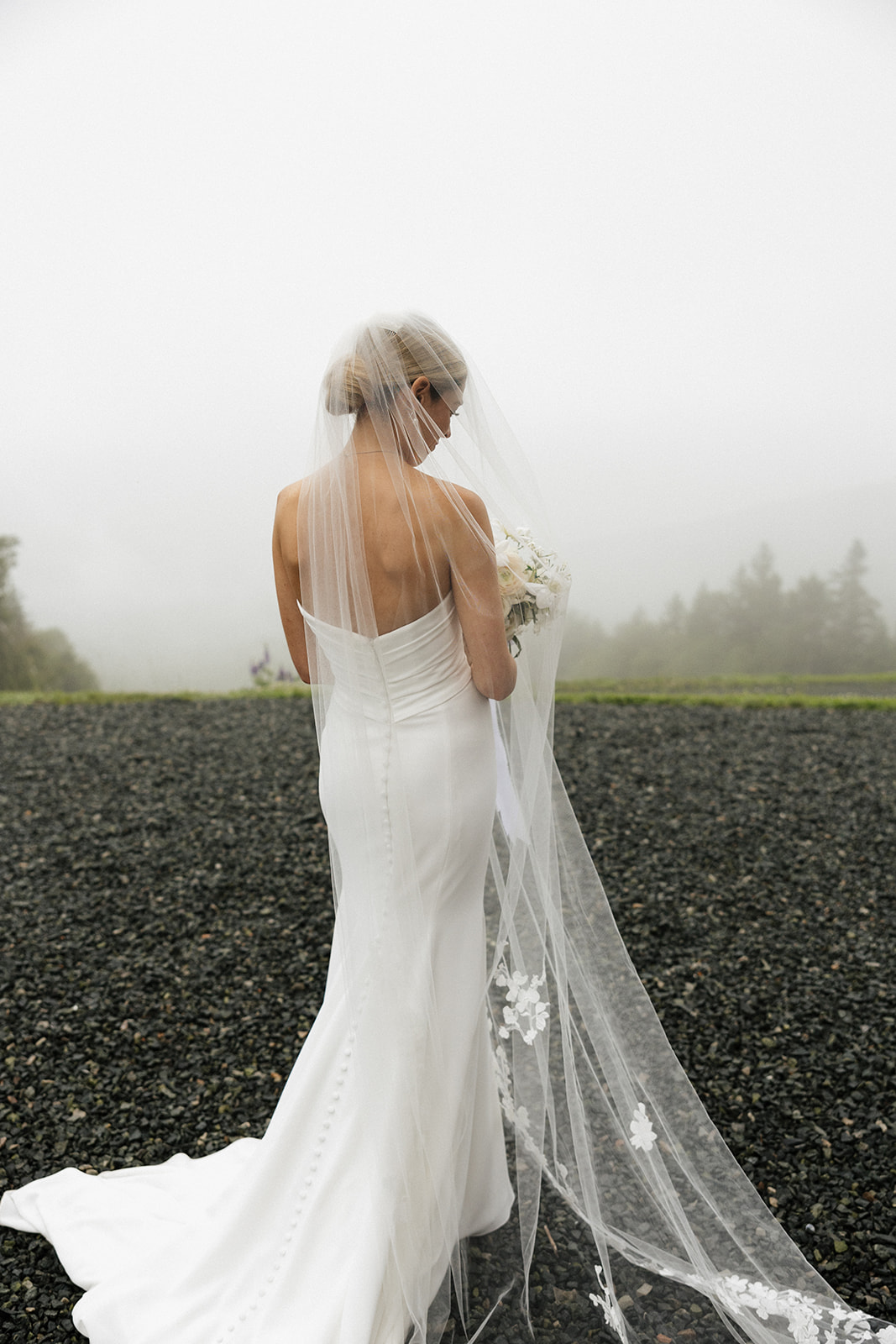 bride poses against a green shrub