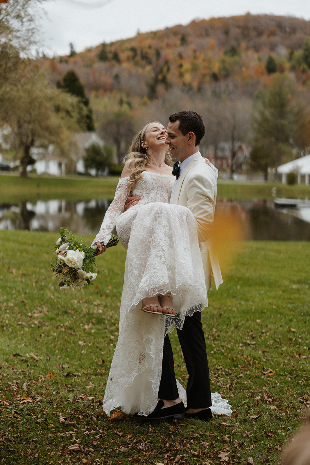 groom carries his bride outside