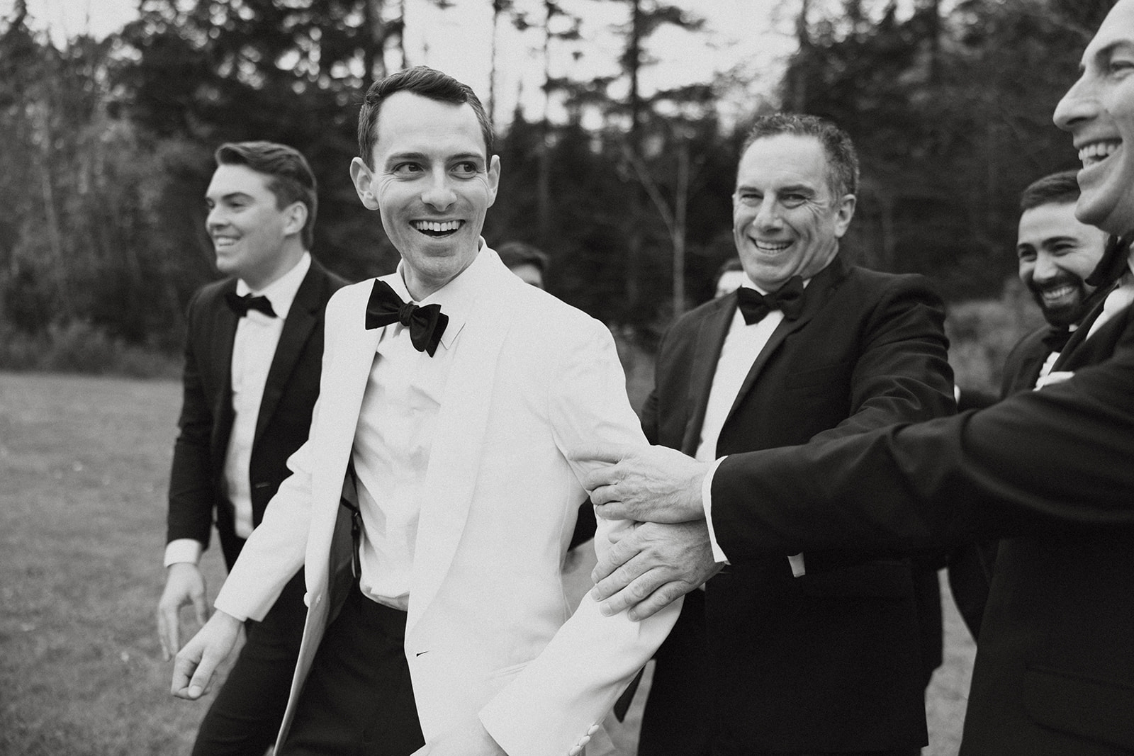 groom poses with his groomsmen before his big day