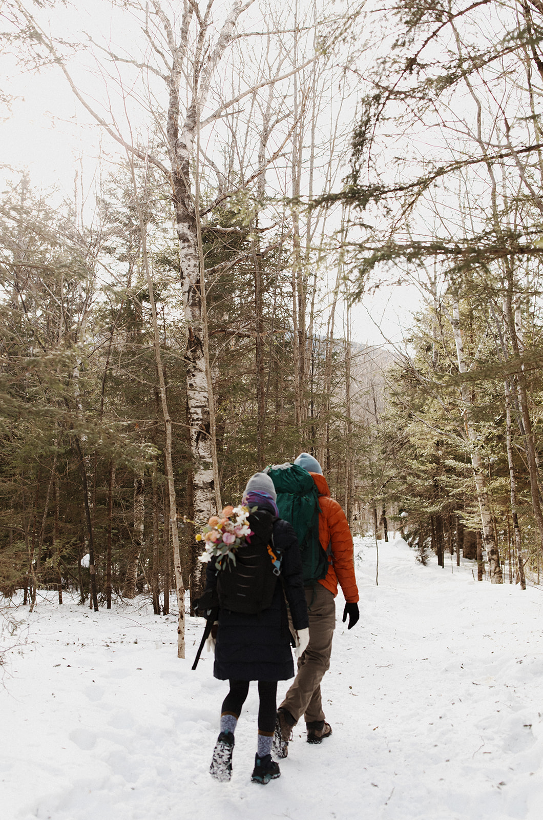 bride and groom hike together to their NH elopement site