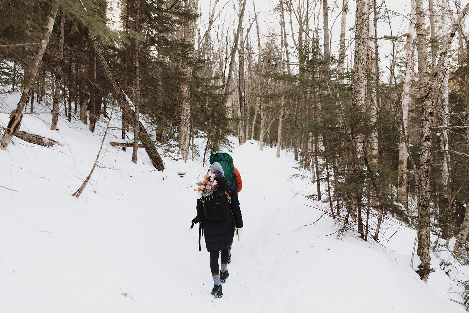 bride and groom hike together to their NH elopement site