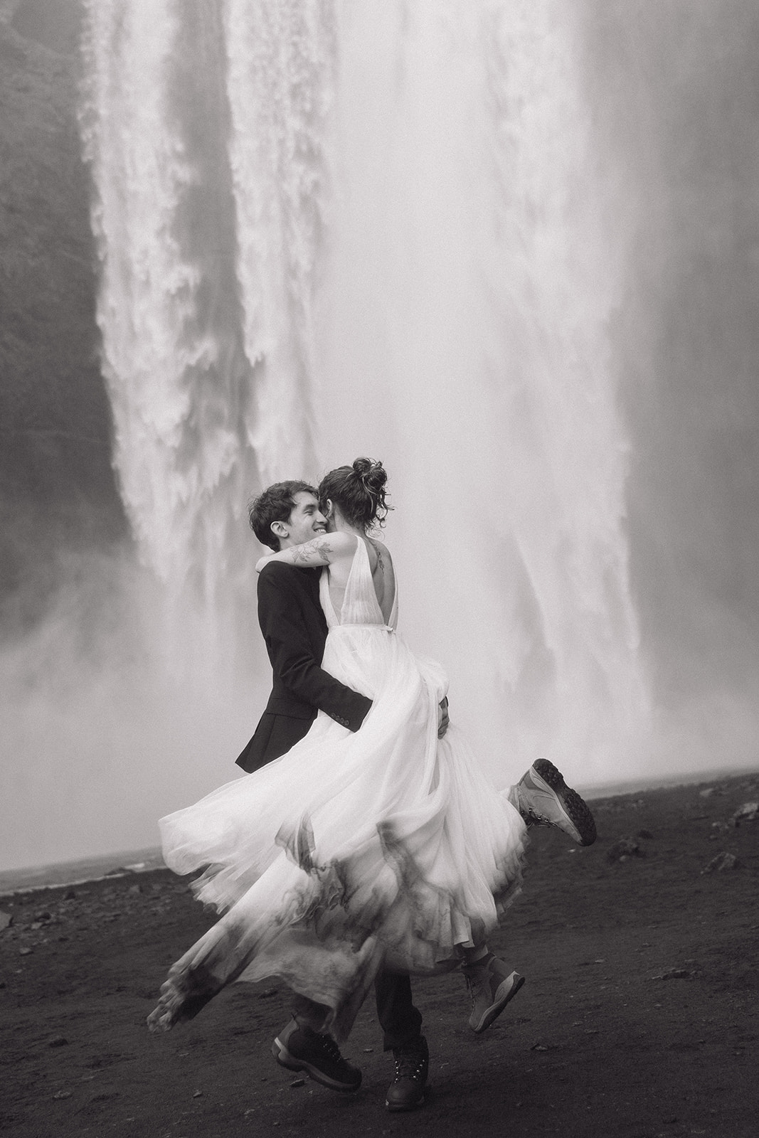 Bride and groom at the bottom of Skogafoss waterfall during their Iceland elopement