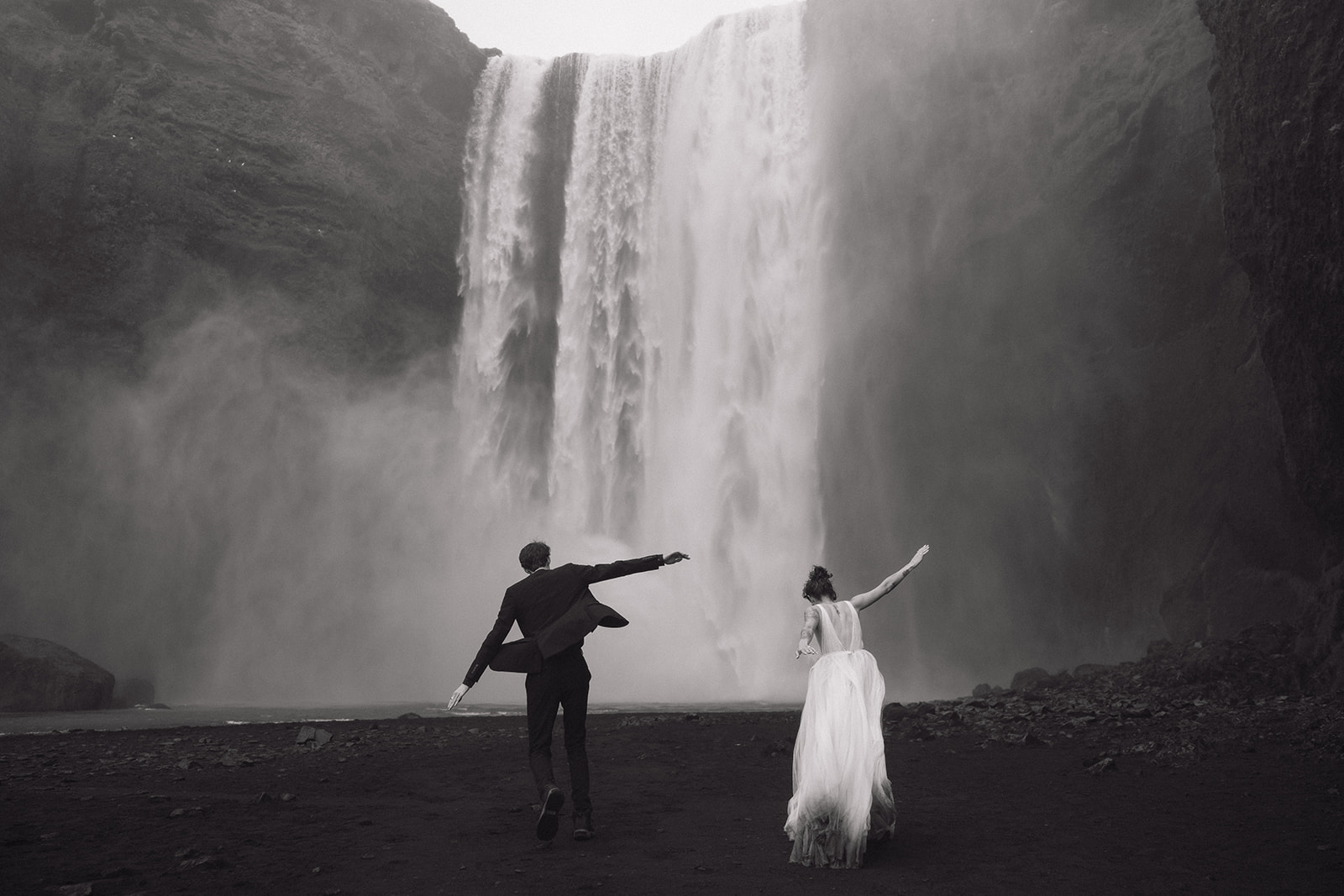 Bride and groom pose at Skogafoss waterfall during their Iceland elopement