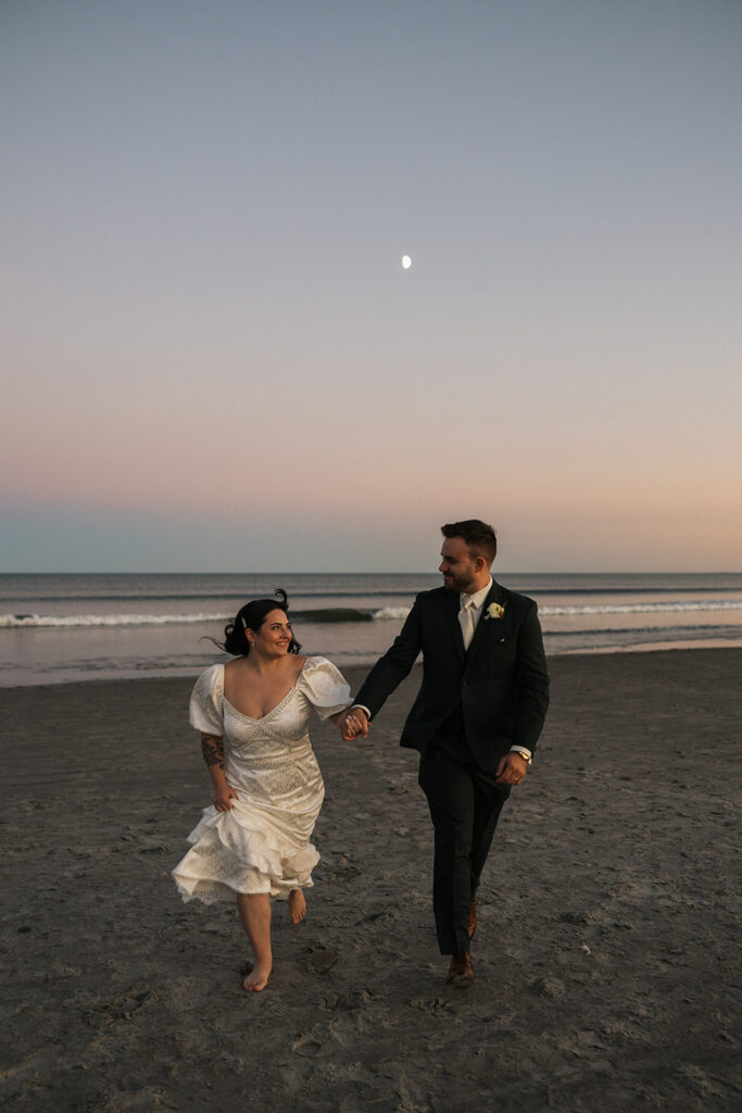 documentary style photo of a bride and groom running on the beach